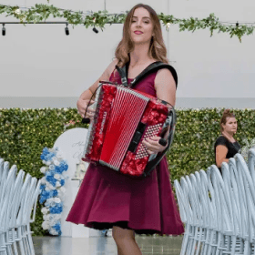 Lucy performing her accordion in a red dress