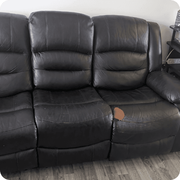 [IMAGE: damaged recliner | alt: "Black leather recliner sofa with torn seat, the damage behind a furniture protection claim"]