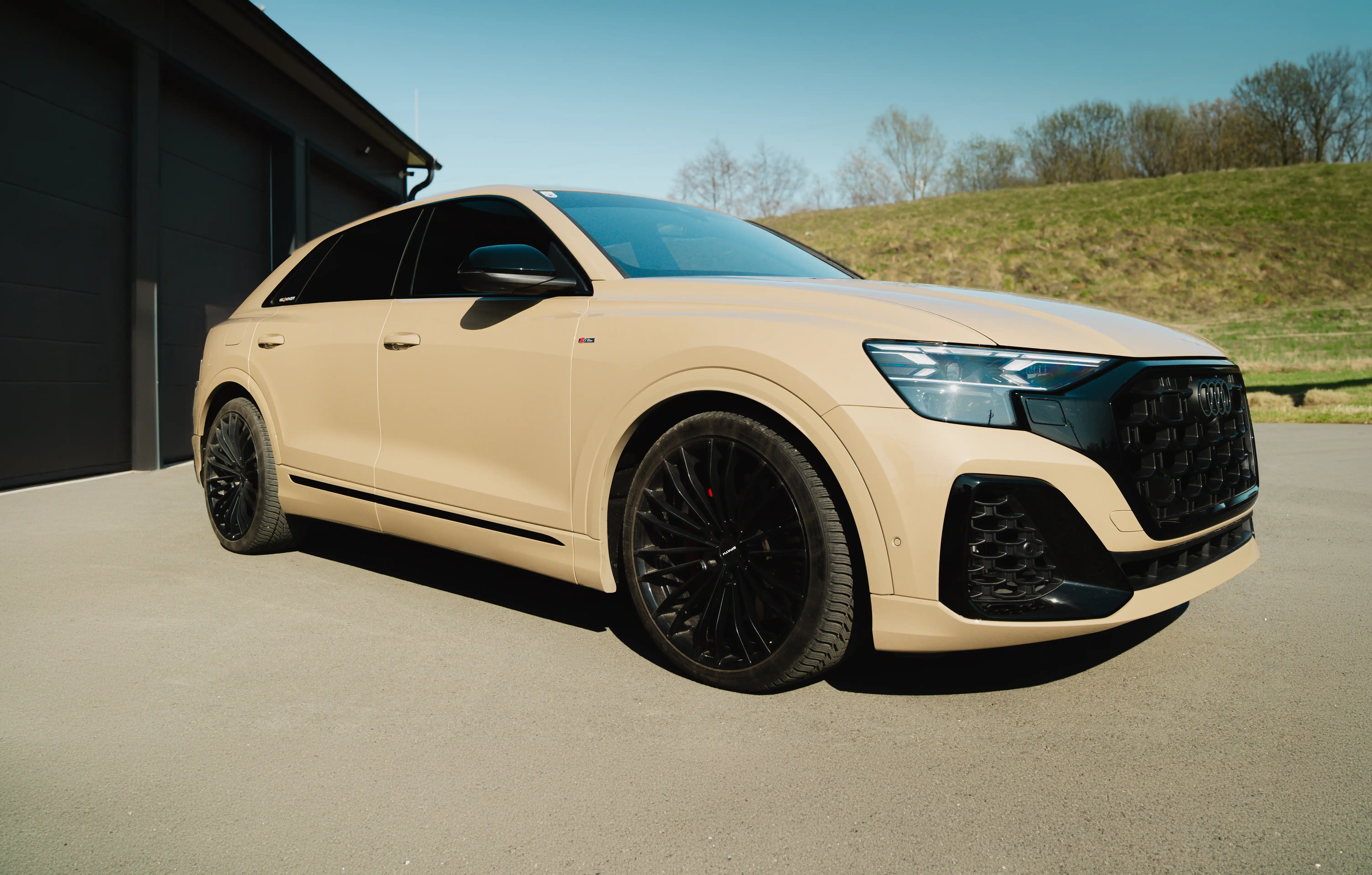 Seitenansicht eines Audi Q8 mit blickdichter 95 % Scheibentönung an den hinteren Seitenscheiben und Heckscheibe, sowie einem Sonnenblendstreifen an der Windschutzscheibe.