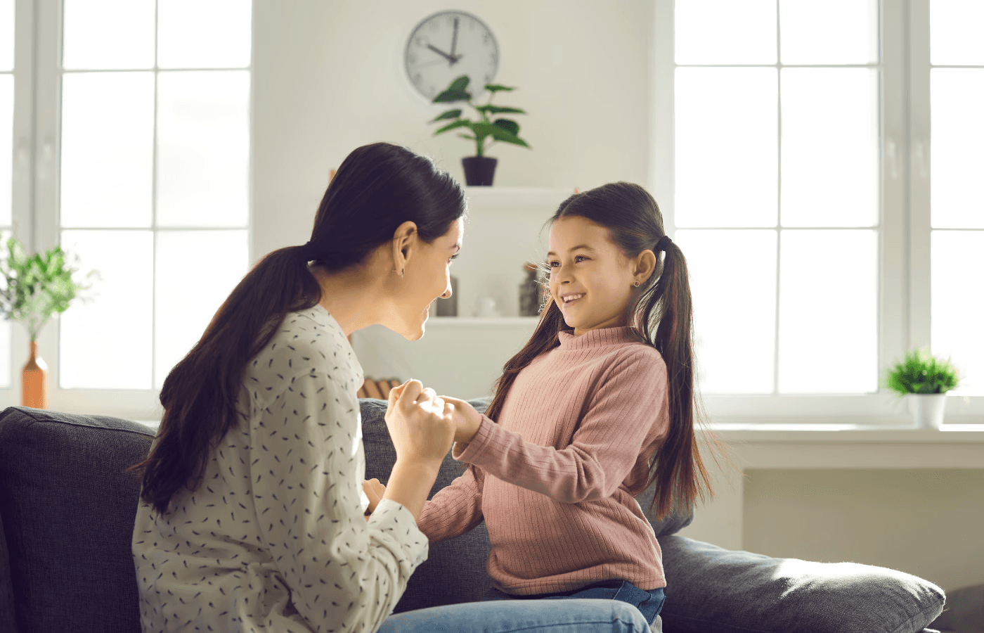 mother and daughter hold hands and look at each other