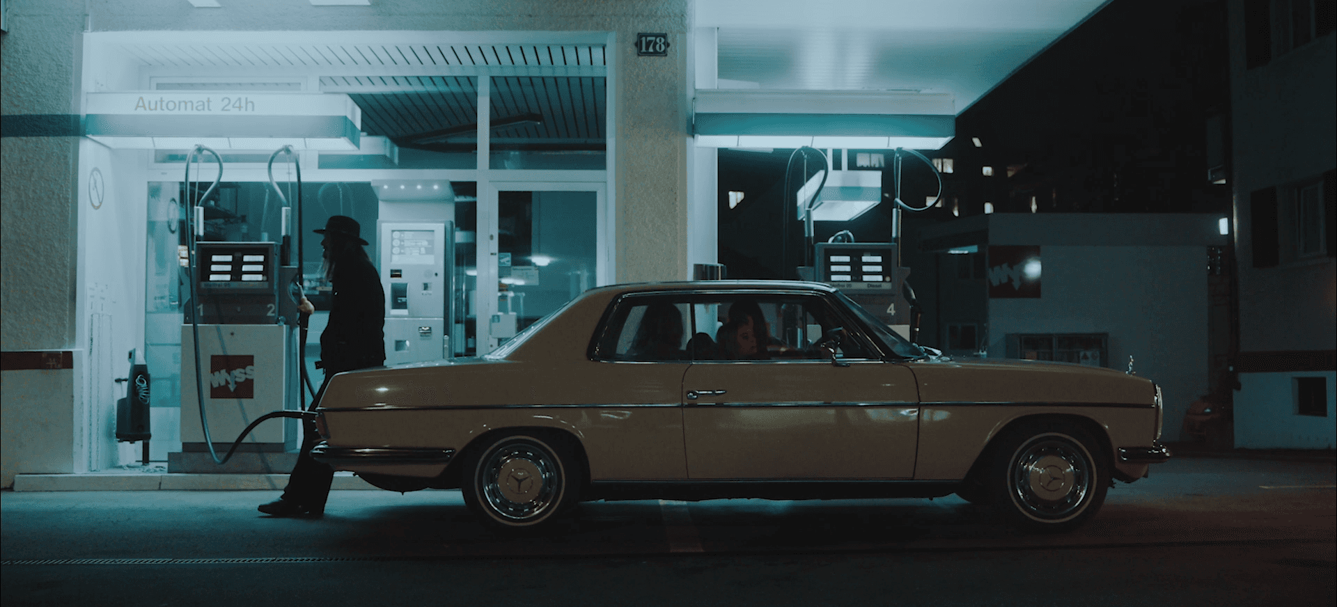 Two fathers carrying children on shoulders on a mountain path.