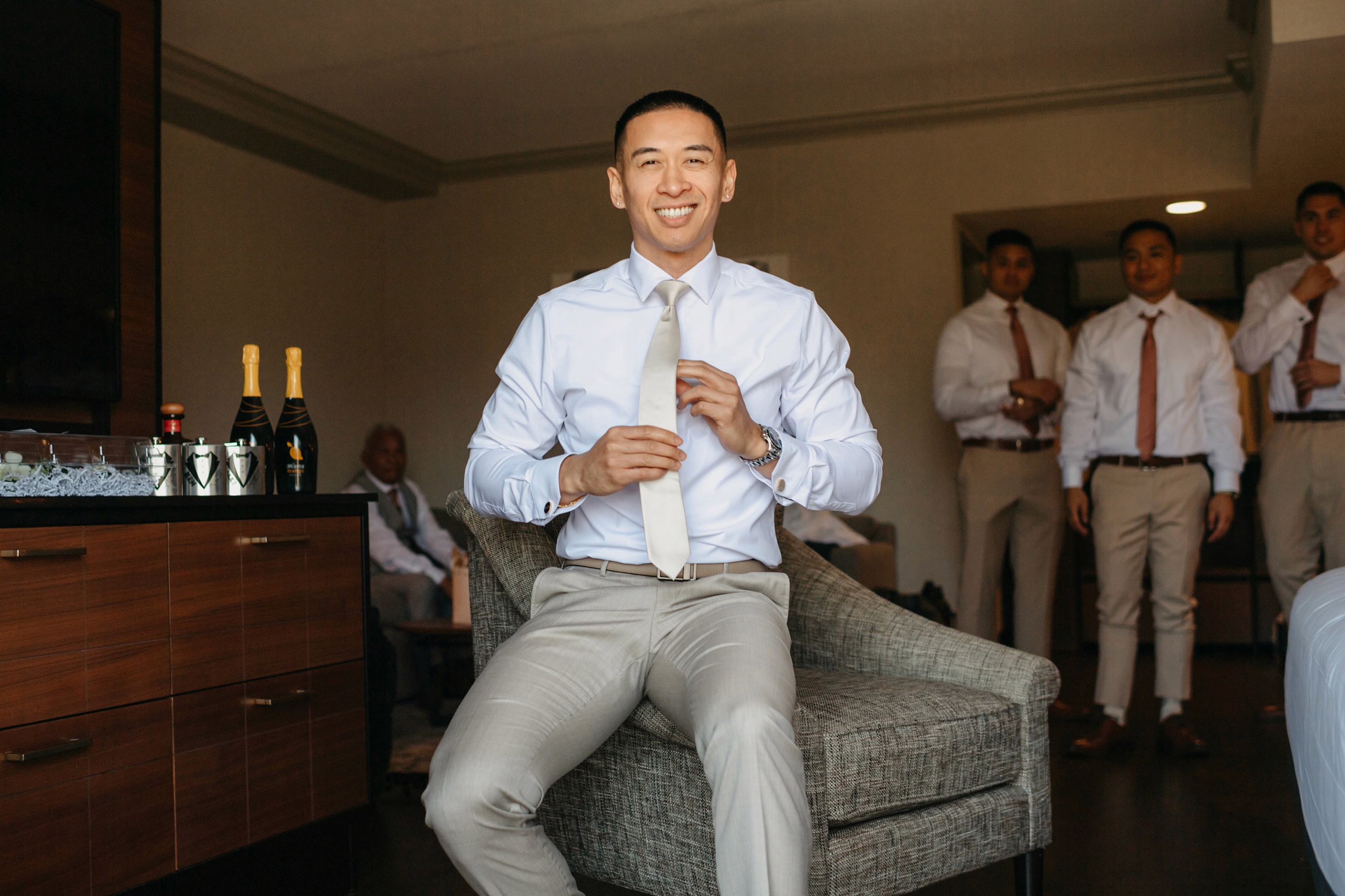 Groom adjusting tie during getting ready photos