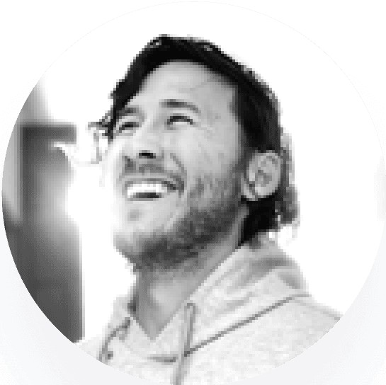 Markiplier, a man smiling person with medium-length hair, looking upwards, captured in a circular black-and-white format.