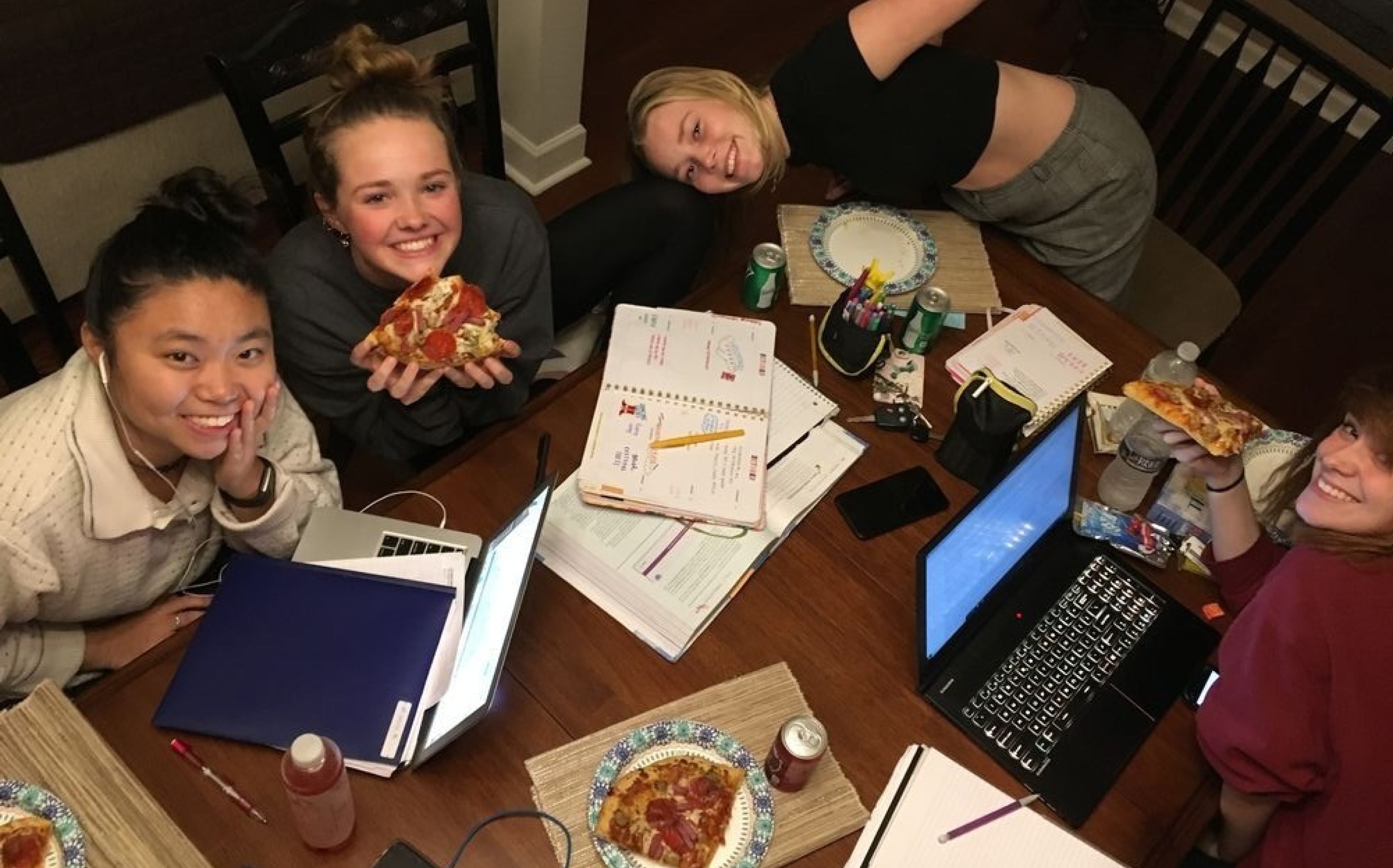 Cozy apartment scene with friends sitting on the floor and couch, doing budgeting and scheduling on their devices.