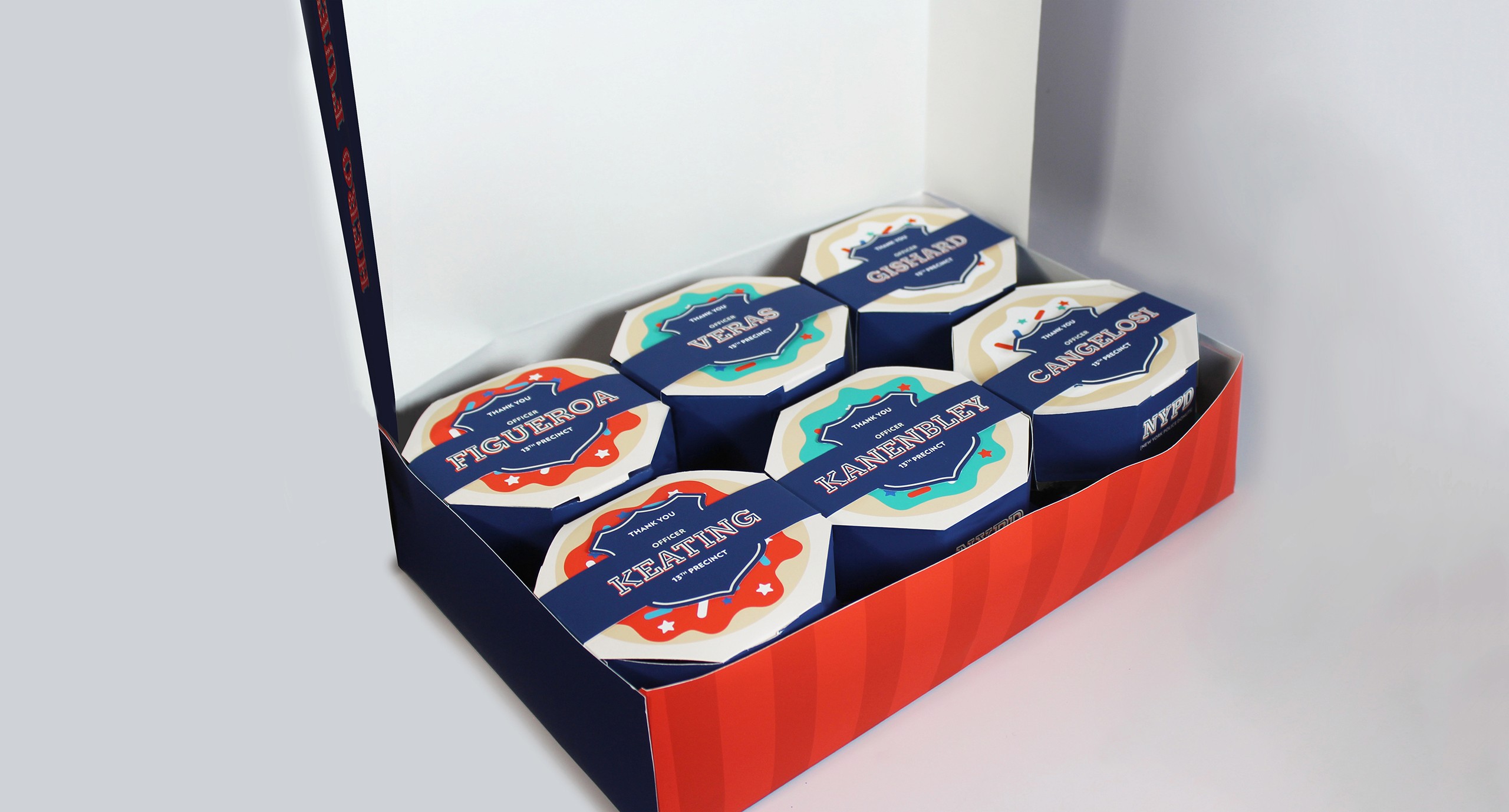 A big box containing multiple smaller boxes with the NYPD logo and also each having a unique name on them.