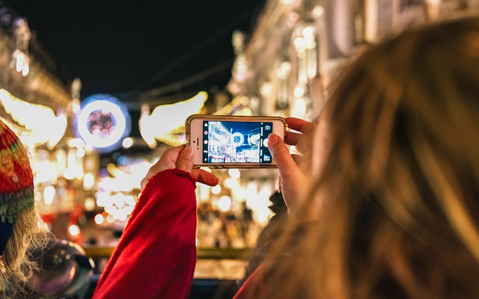 Person photographing London Christmas lights from Tootbus tour.