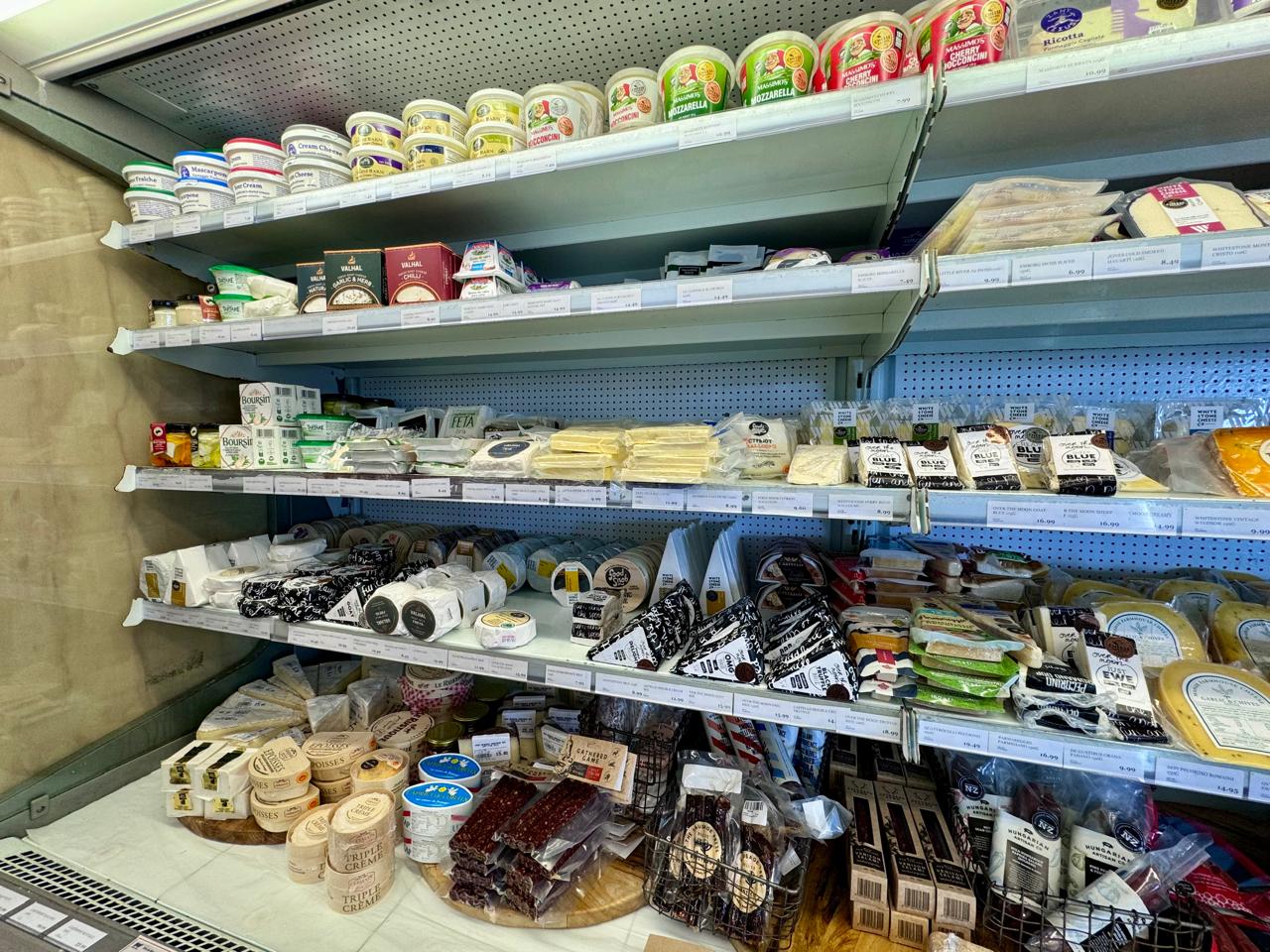 Shelves stacked with cheese and other goods in a store in Waiheke island
