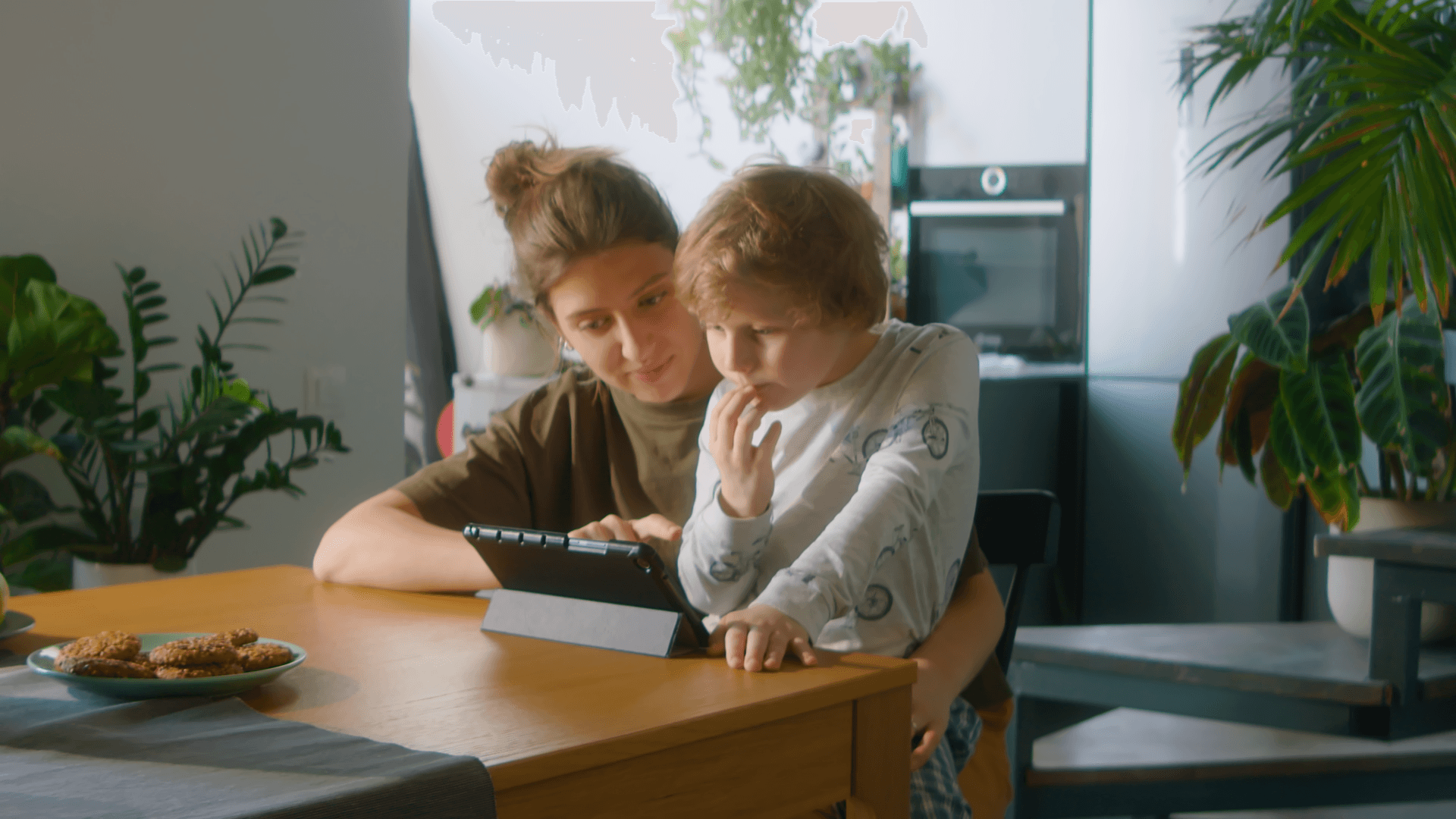A women and a child using a tablet.