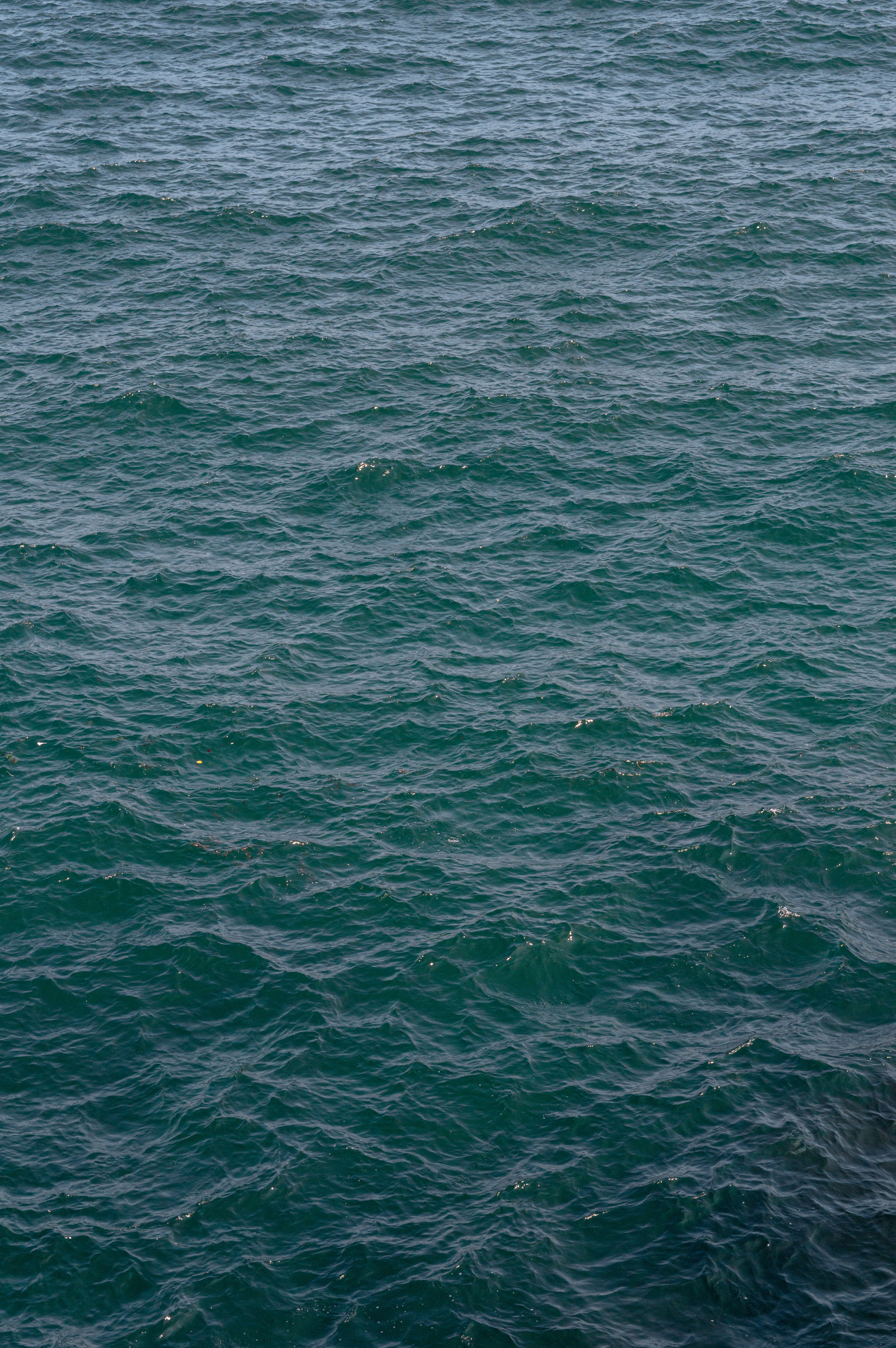 a man riding a surfboard on top of a large body of water