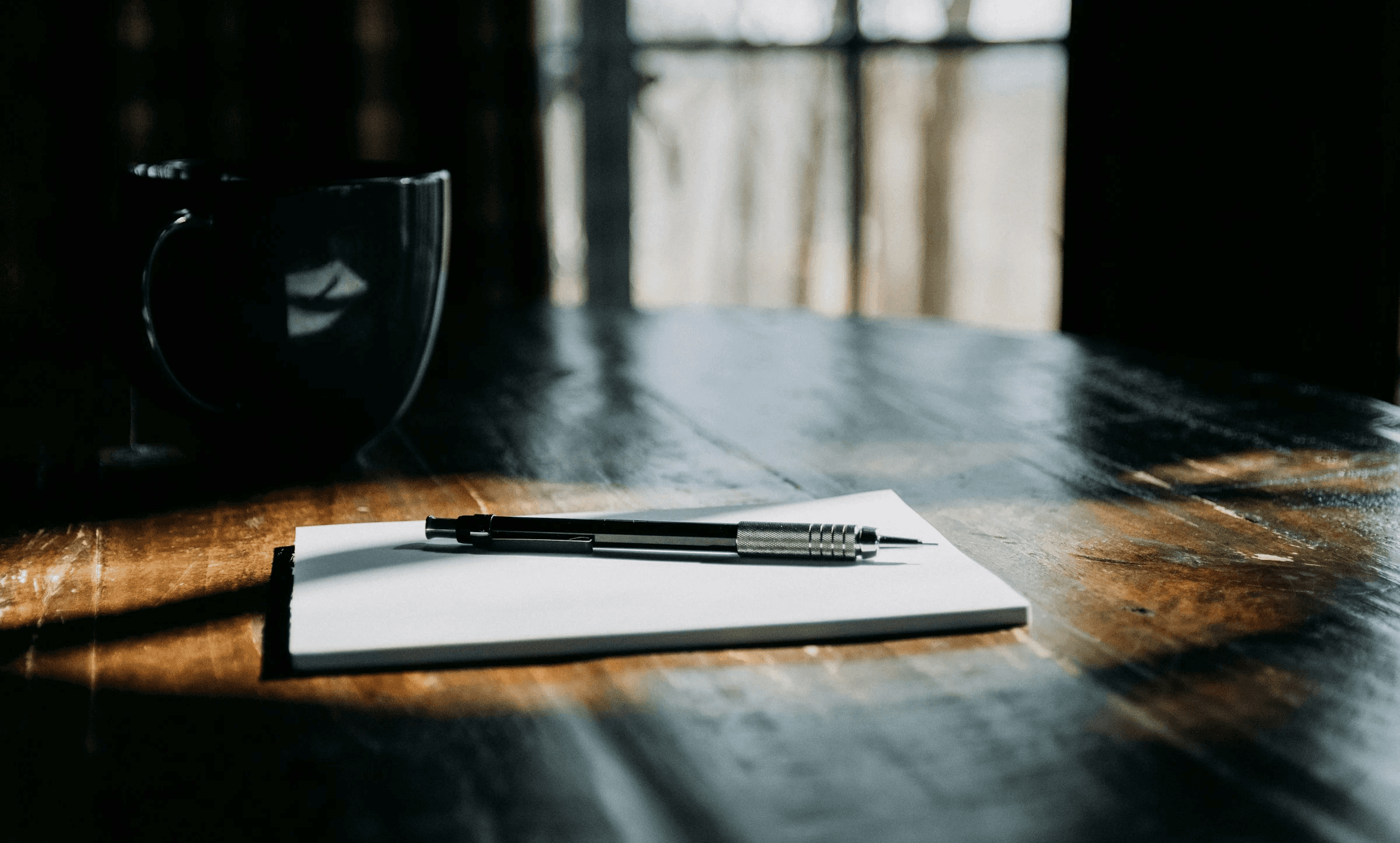 Notizbuch und Kaffeetasse auf Holztisch