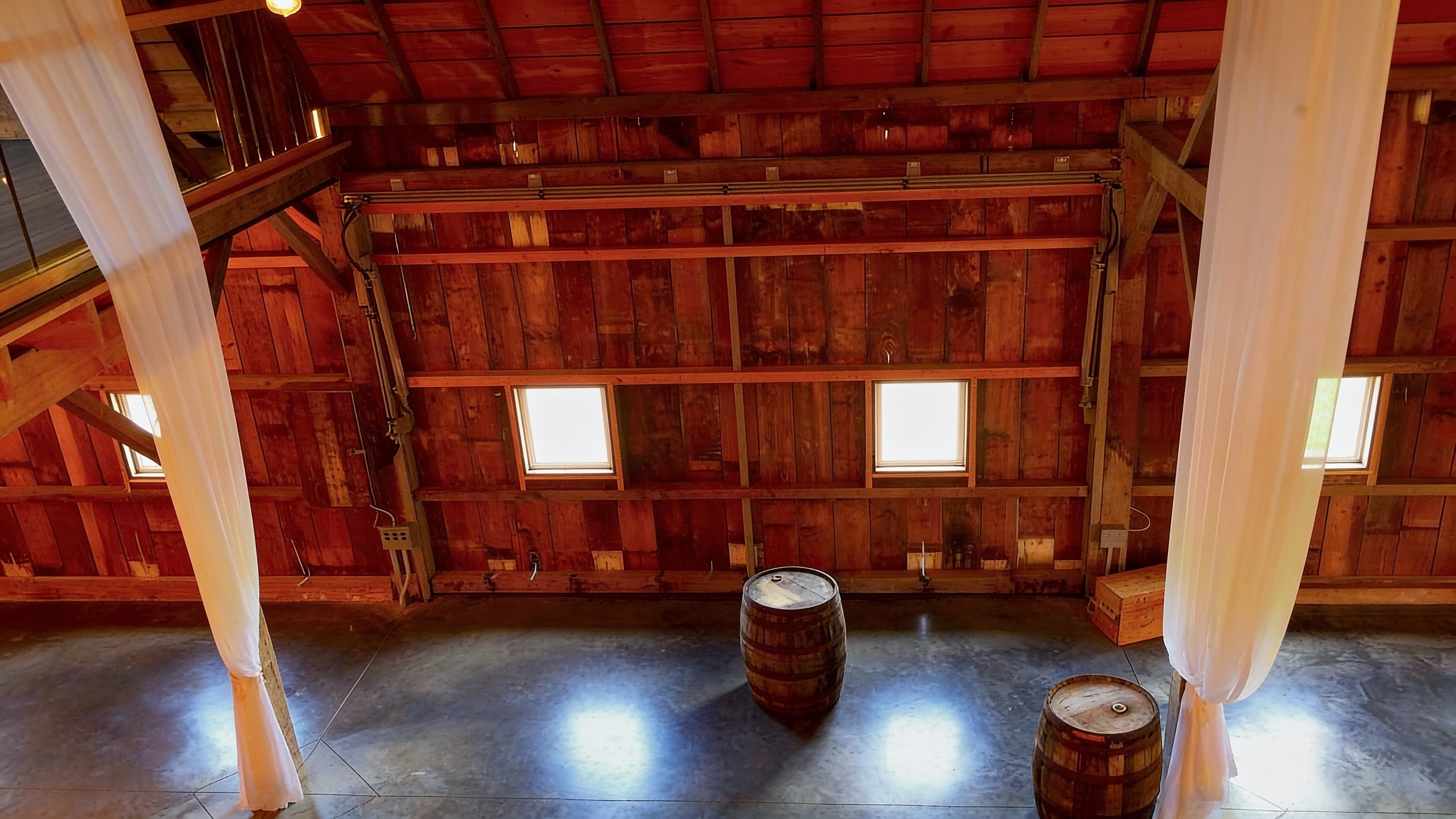 Rustic barn venue interior with an open hydraulic door to a patio