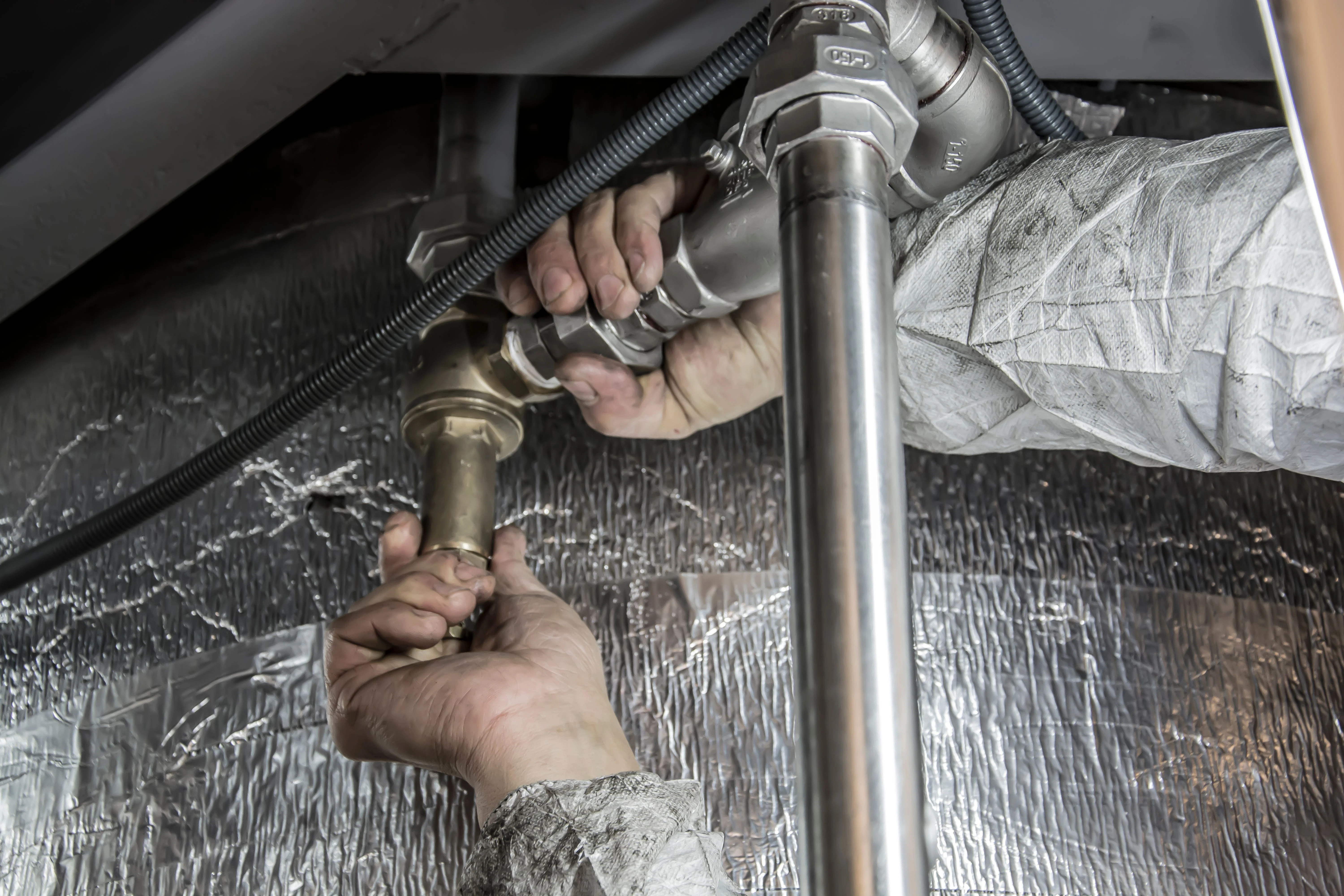 Plumber contractors working fixing a pipe | Plumber CRM