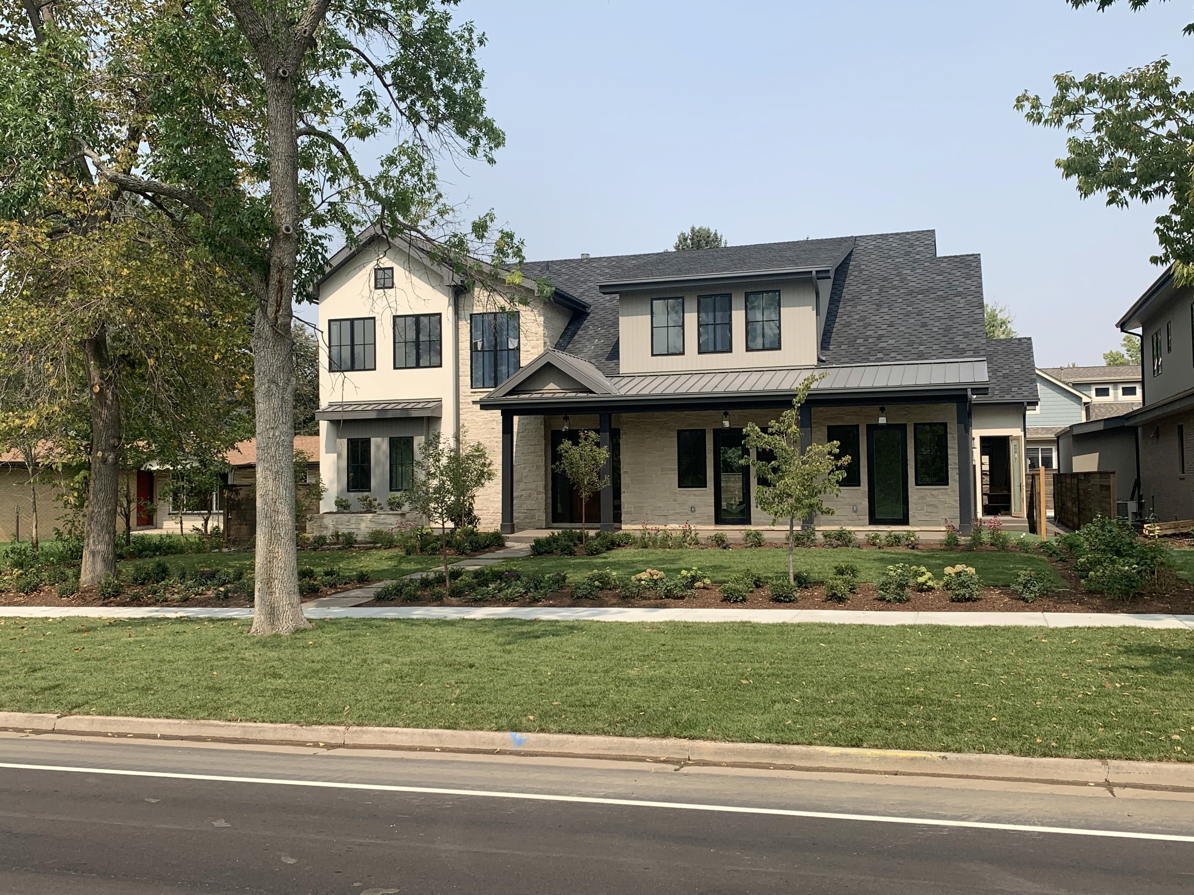 modern farmhouse style home in Colorado neighborhood, with large front yard and sidewalk view