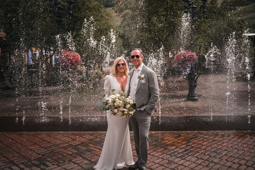 Newlyweds posing in front of a fountain