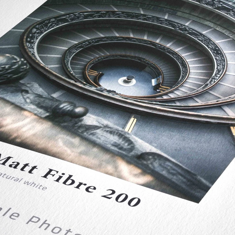 Zbliżenie na wydruk zdjęcia na papierze Hahnemühle Matt Fibre 200 z widoczną fakturą papieru i fragmentem spiralnych schodów