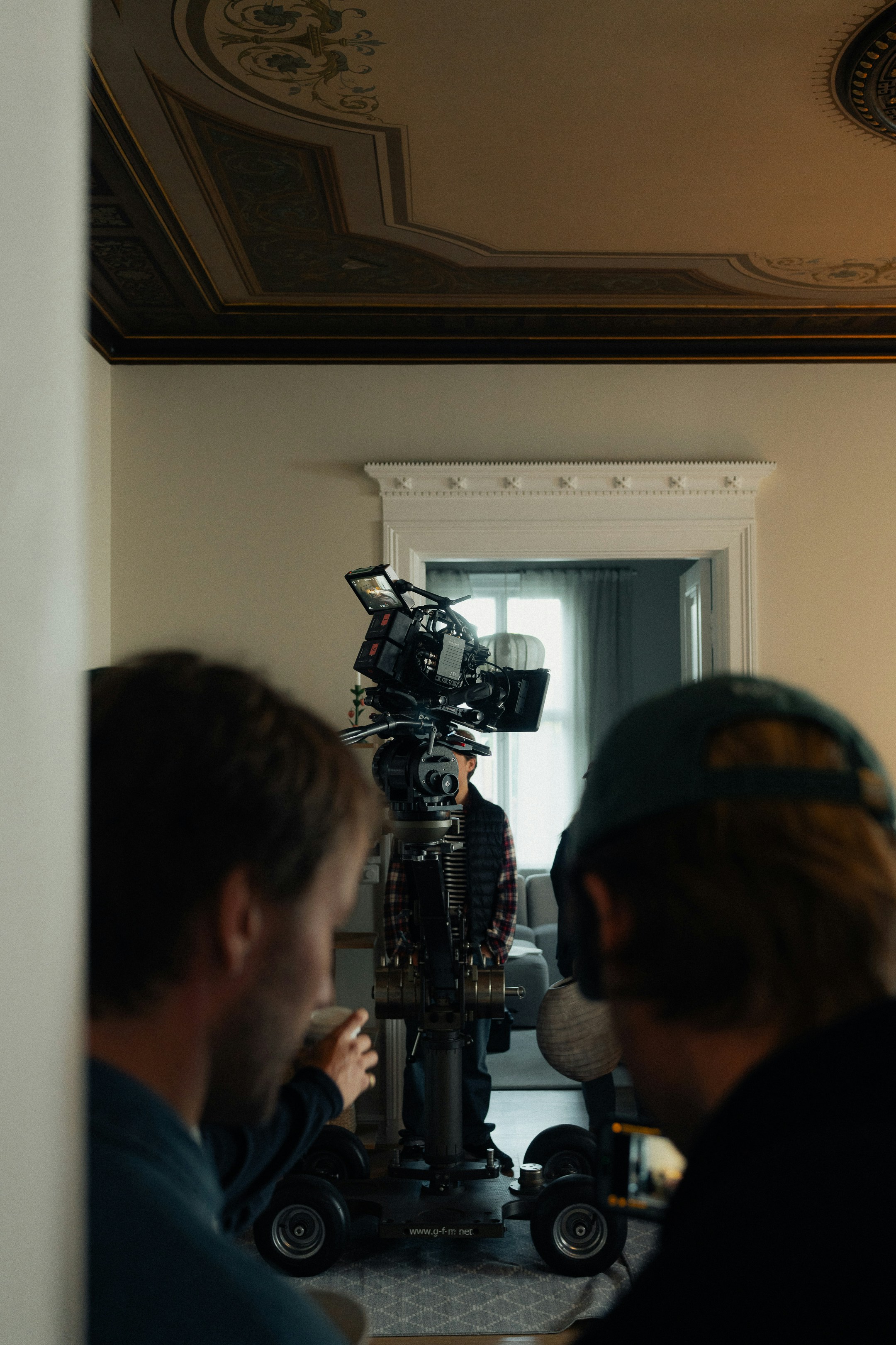 Filming crew with camera on dolly in room