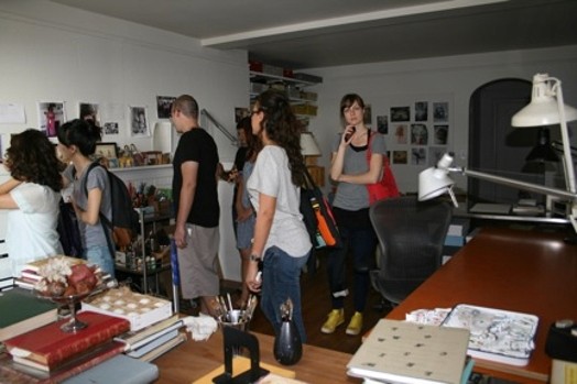 A photo of a group of students looking at different pictures on the walls.