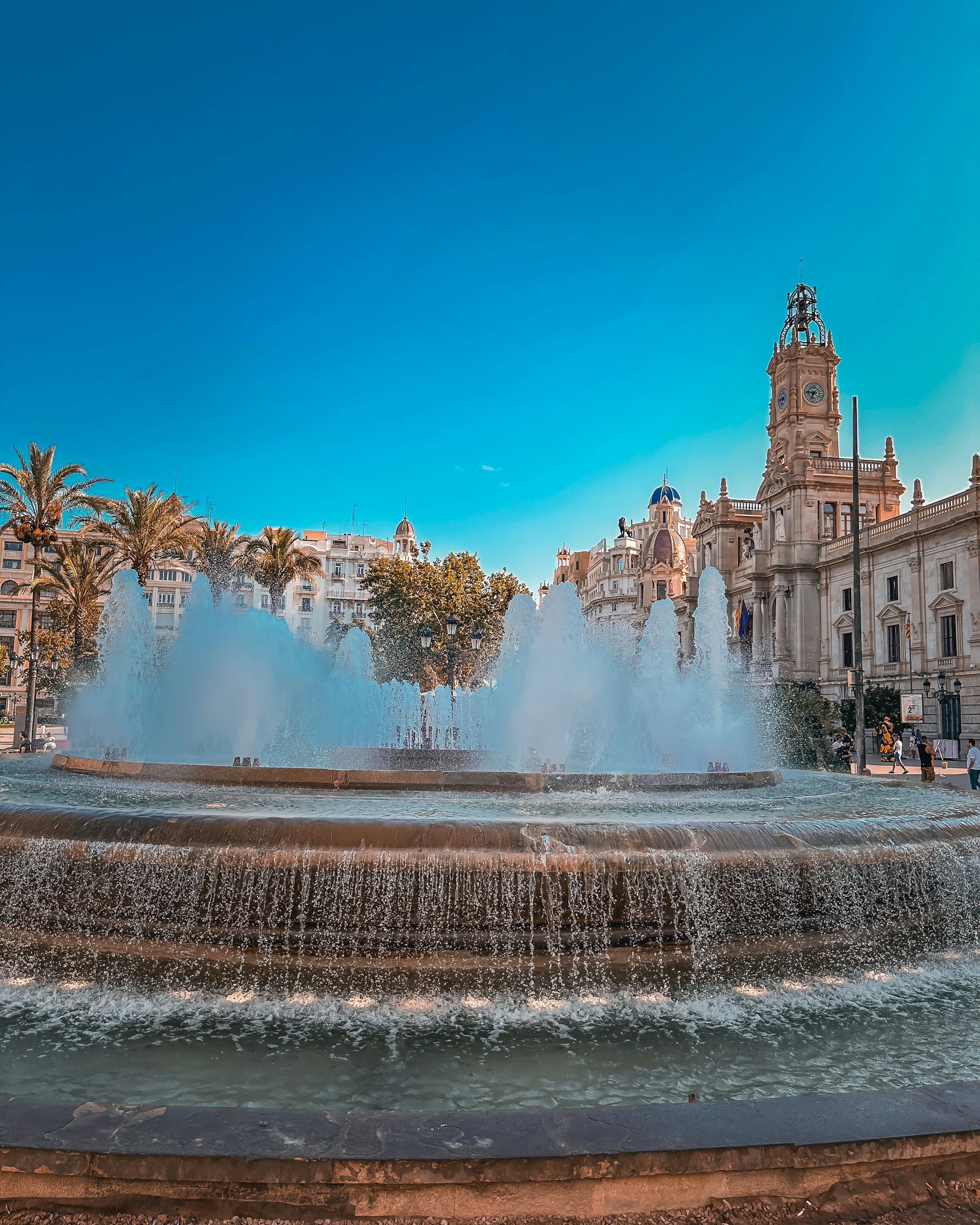 a water fountain in front of a building with a clock tower