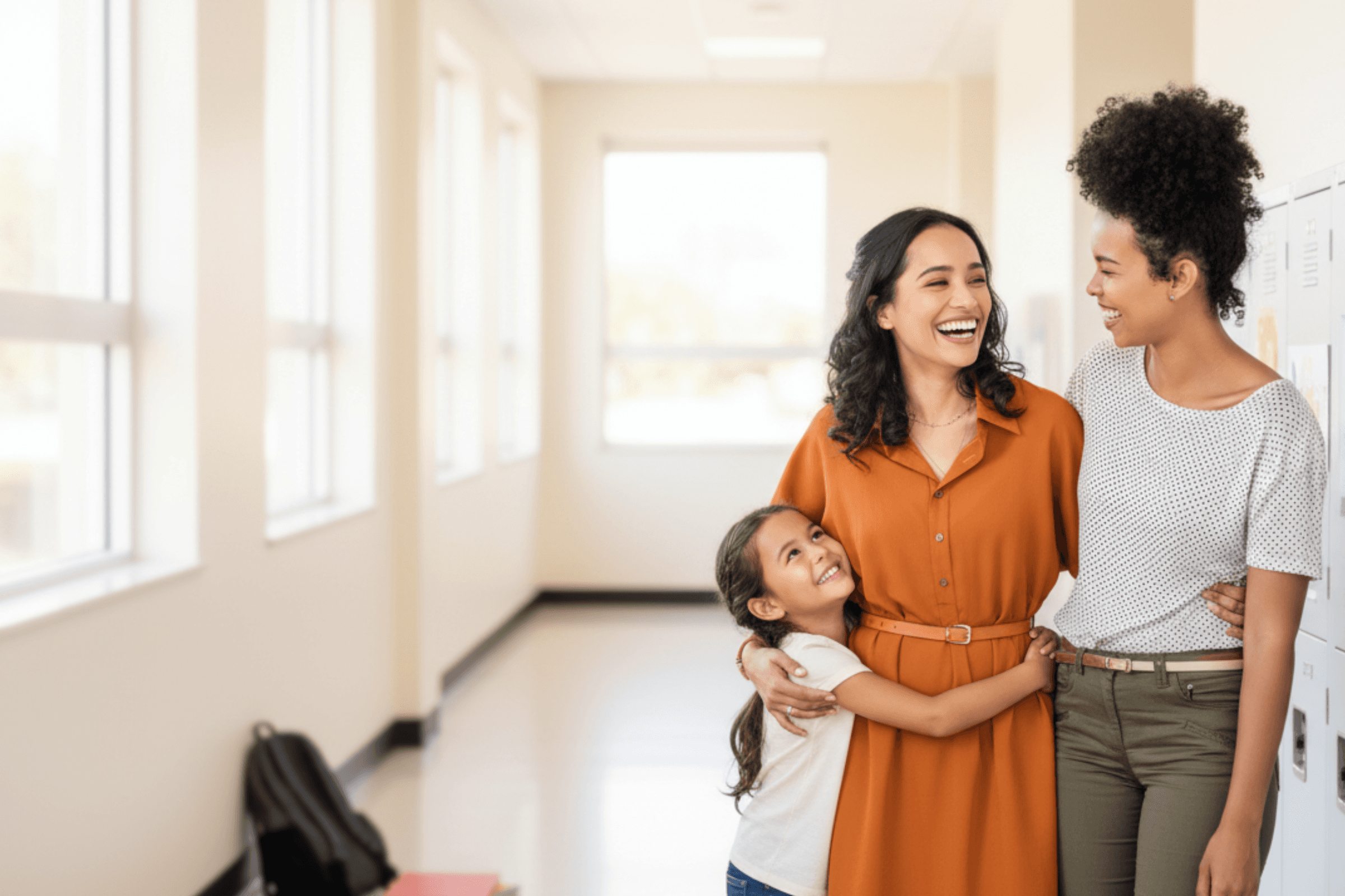 Two diverse teachers smiling together, reinforcing Kina’s mission to **reward families and retain top teachers