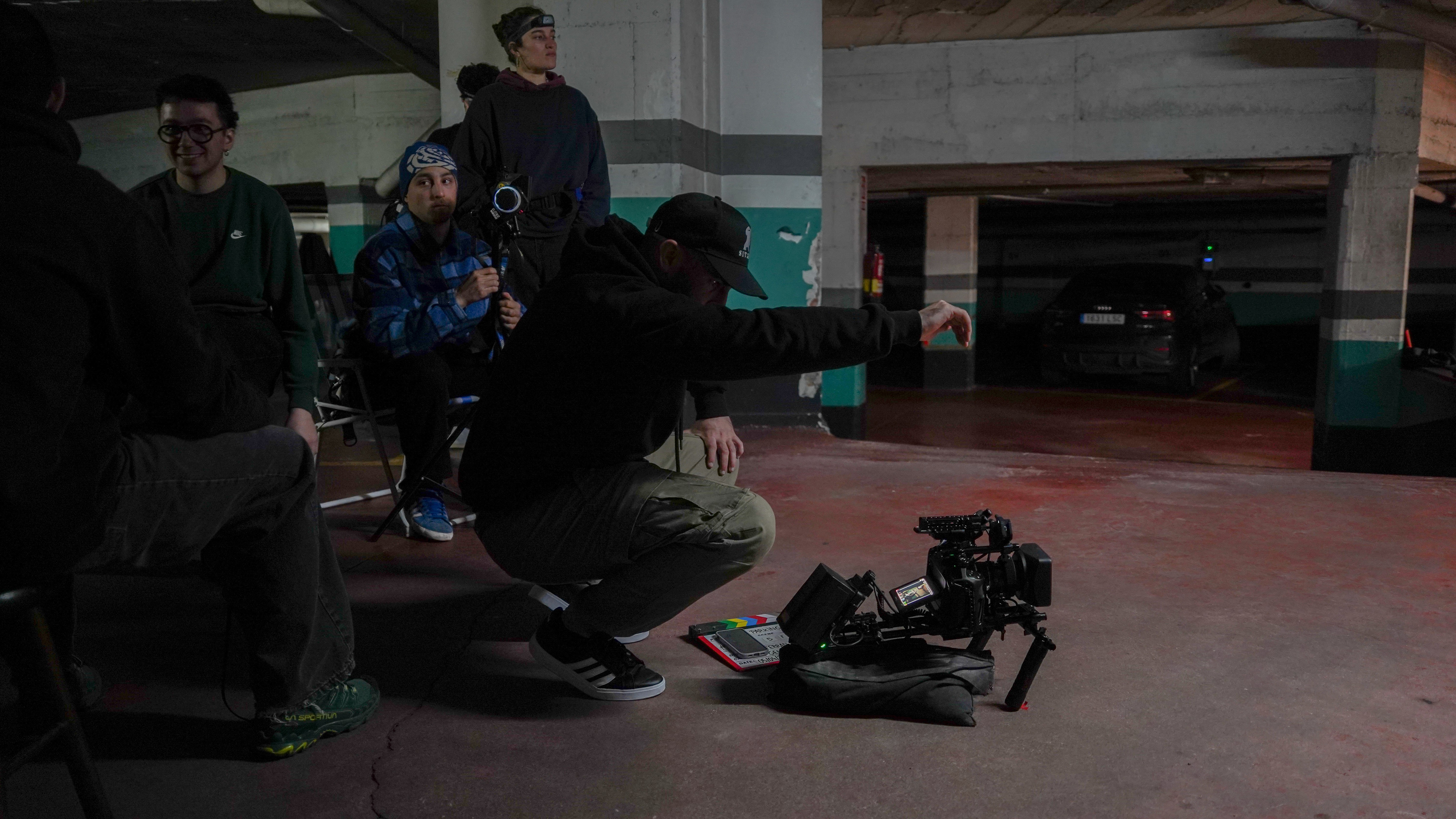 Collaborative work session overhead view of six people collaborating at a rustic wooden table with coffee, papers, and a laptop