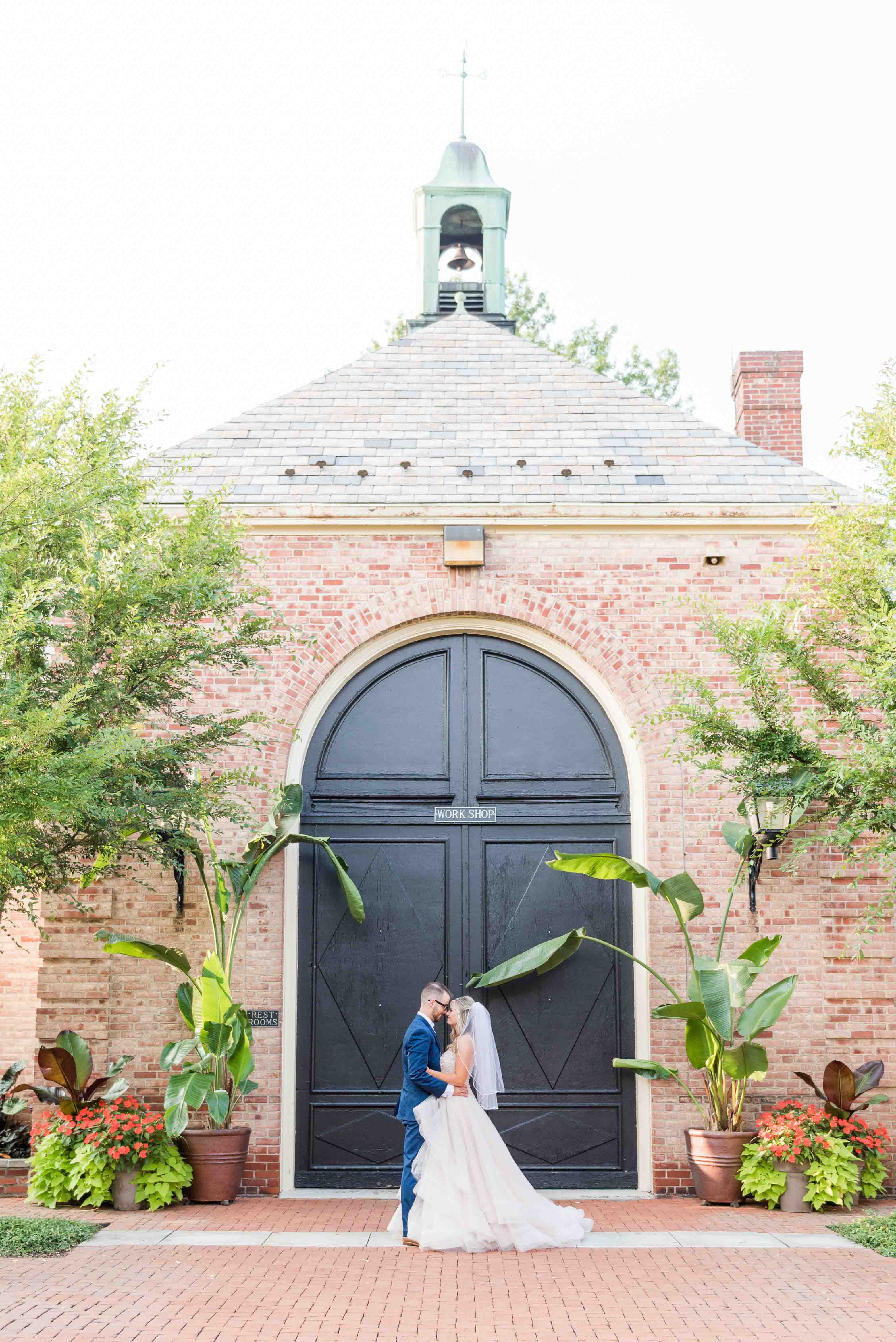 Southern wedding portrait of bride and groom in front of historic mansion.