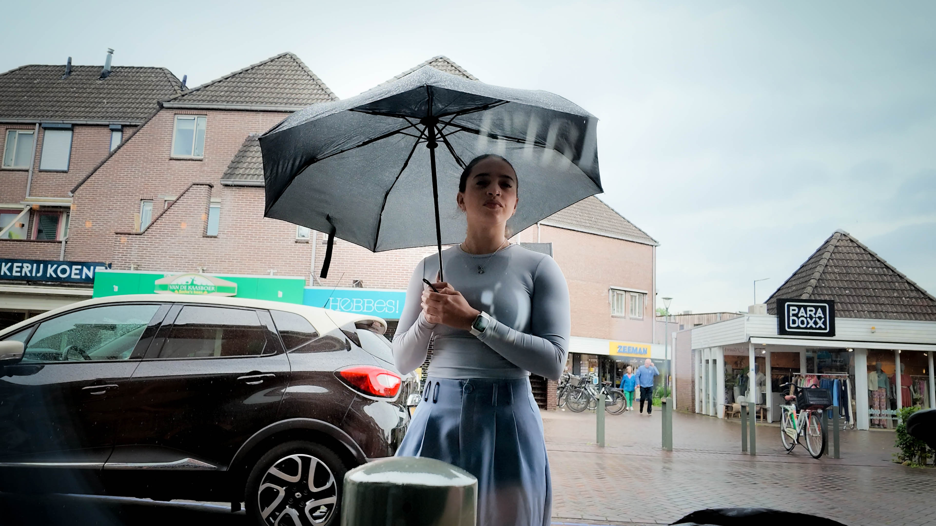 Voorbijganger bekijkt narrowcasting scherm in de etalage van Brillehuus