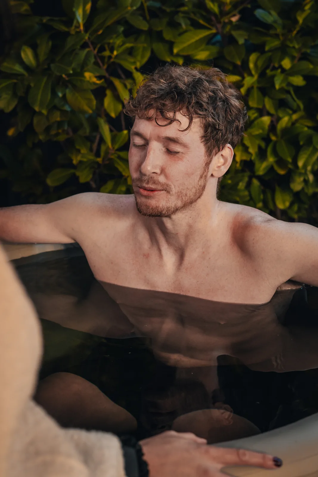 A man relaxing with his eyes closed in an ice bath