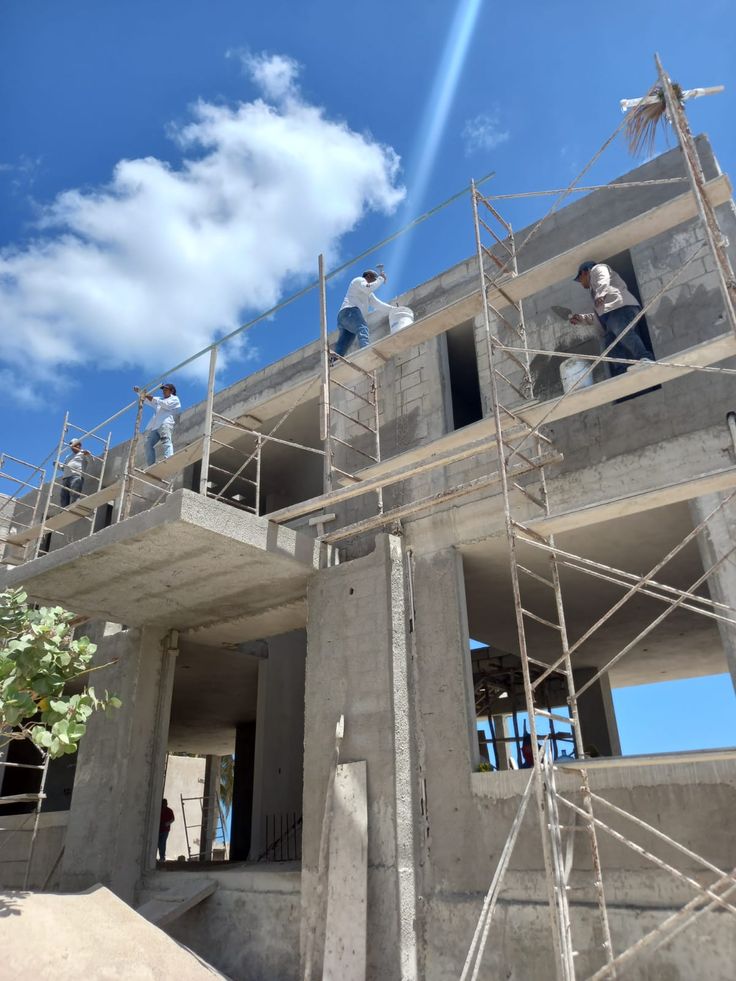 A serene outdoor lounge area with two chairs surrounded by lush greenery and natural light streaming in.
