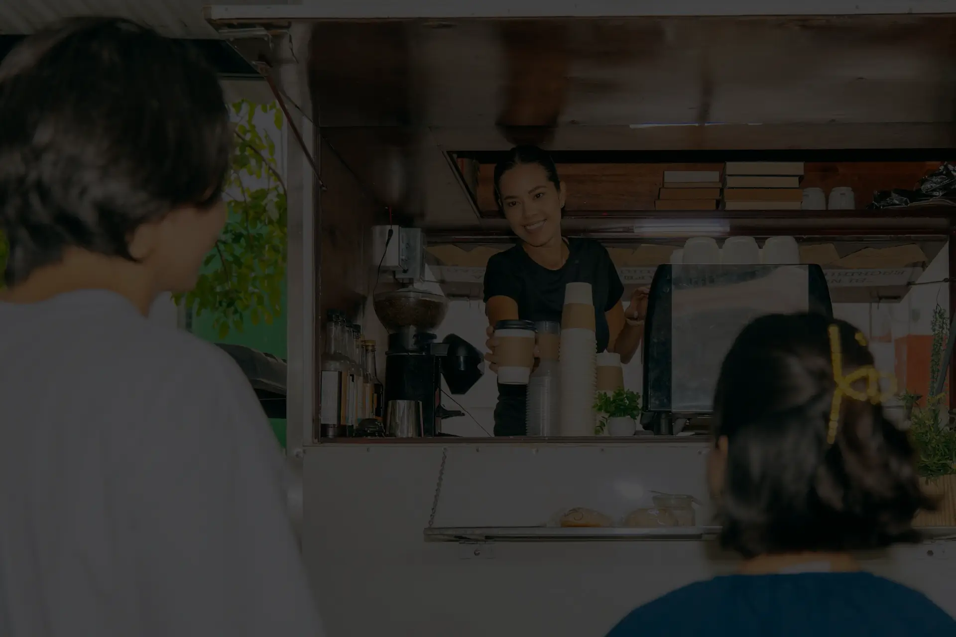 A local Tampa coffee truck serves two patrons, with an employee preparing drinks, showcasing efficient design and integration of business services.