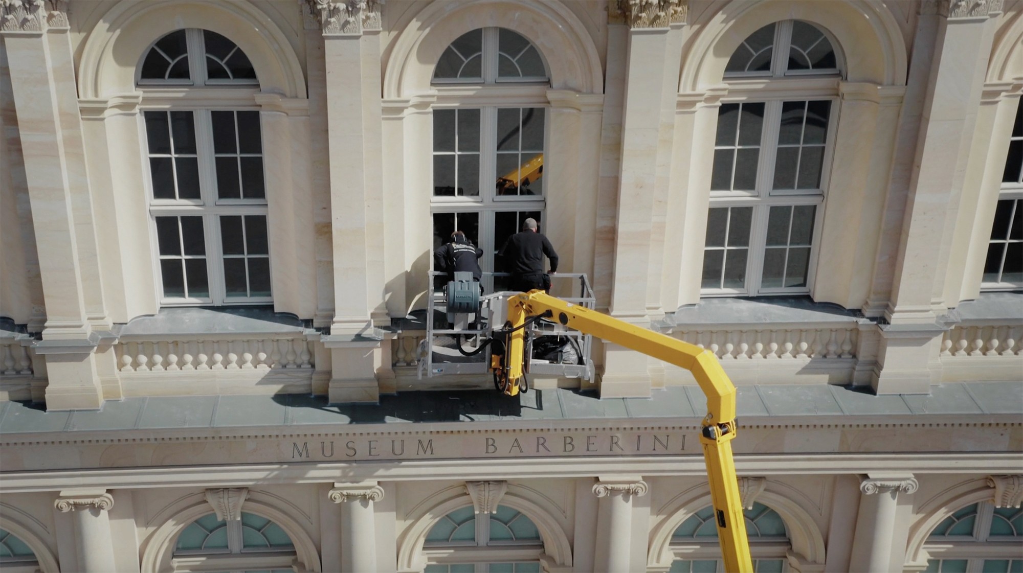 Zwei Monteure auf einem Steiger vor einer Gebäudefassade
