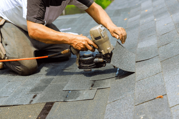 residential roofing services in Arlington installing new asphalt shingles using professional roofing tools.