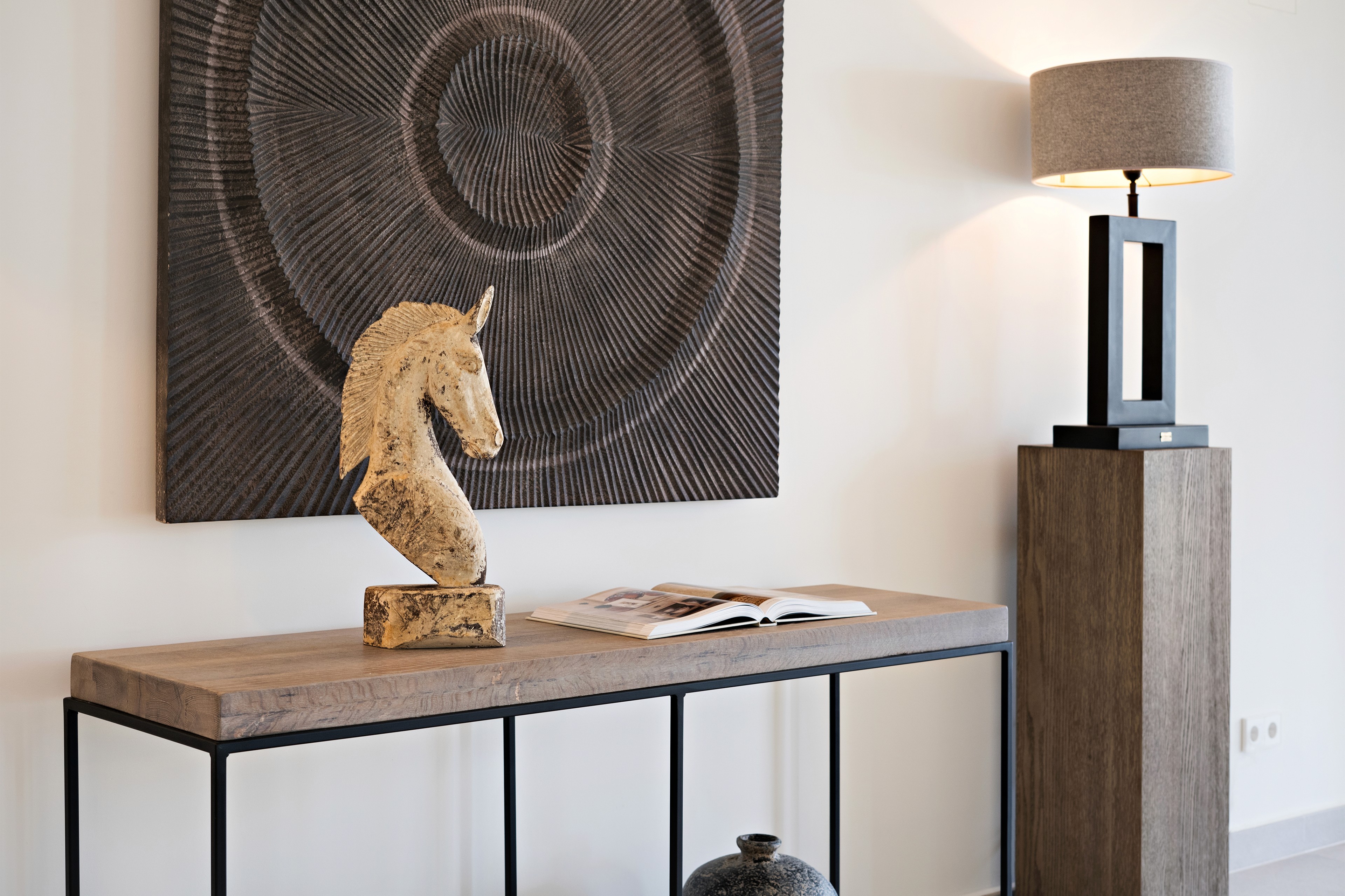 Flur der Villa in Llombards mit Kunstobjekten, Naturmaterialien und ruhiger, reduzierter Gestaltung