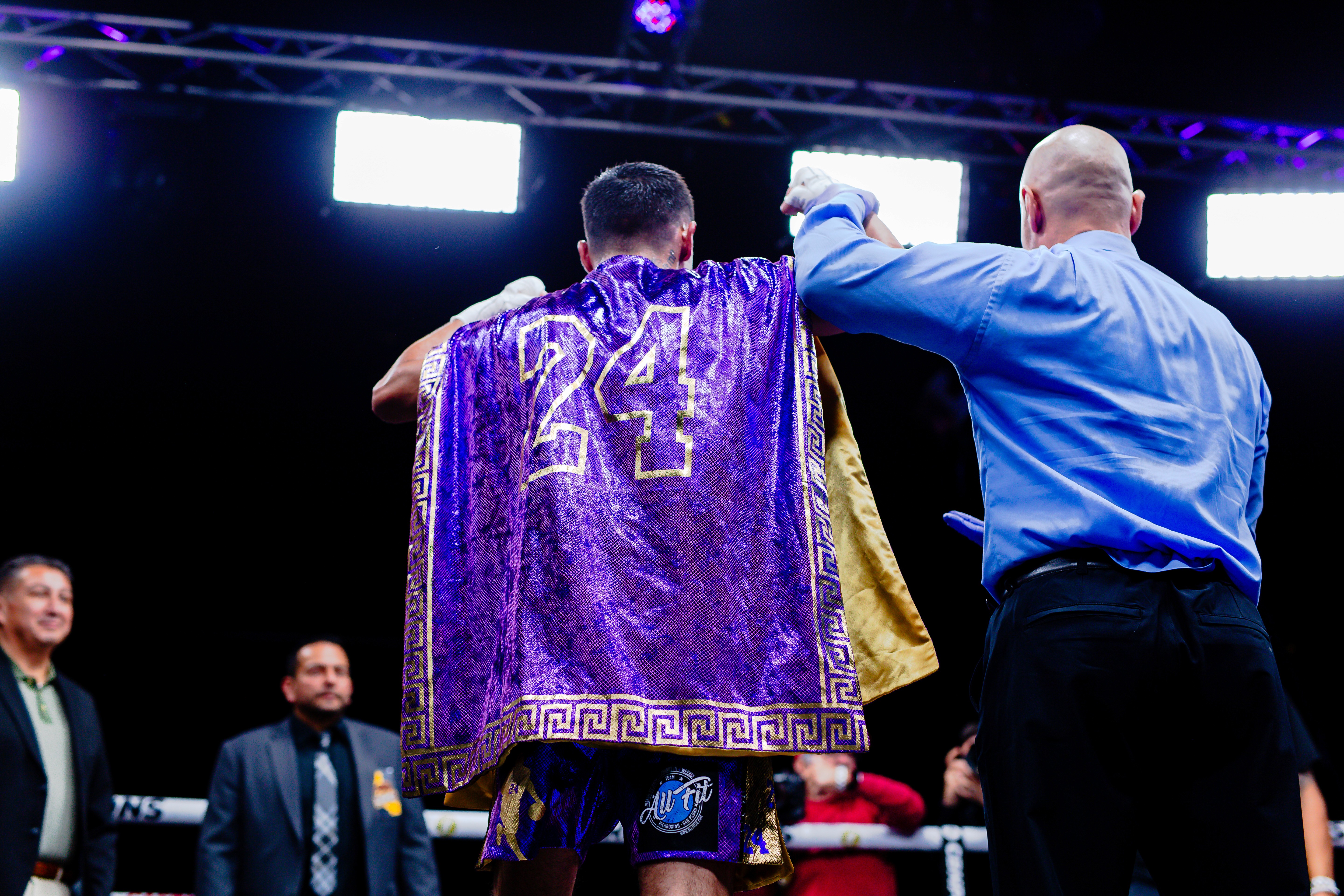 George "El Phantasma" Navarro seen from behind as the referee raises his arms in victory wearing a Lakers colored sarape with the number 24 homage to Los Angeles Kobe and Mexico.