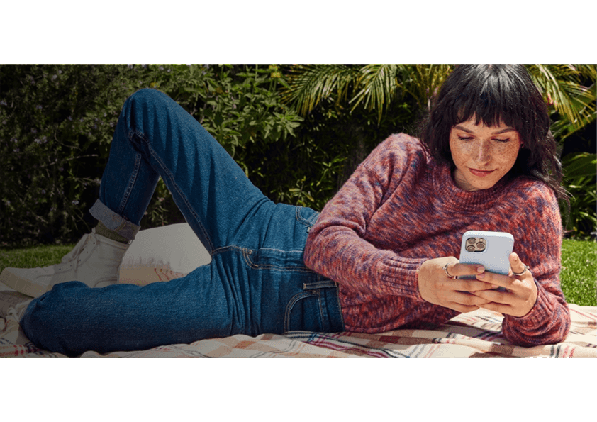 person sitting on grass and using phone