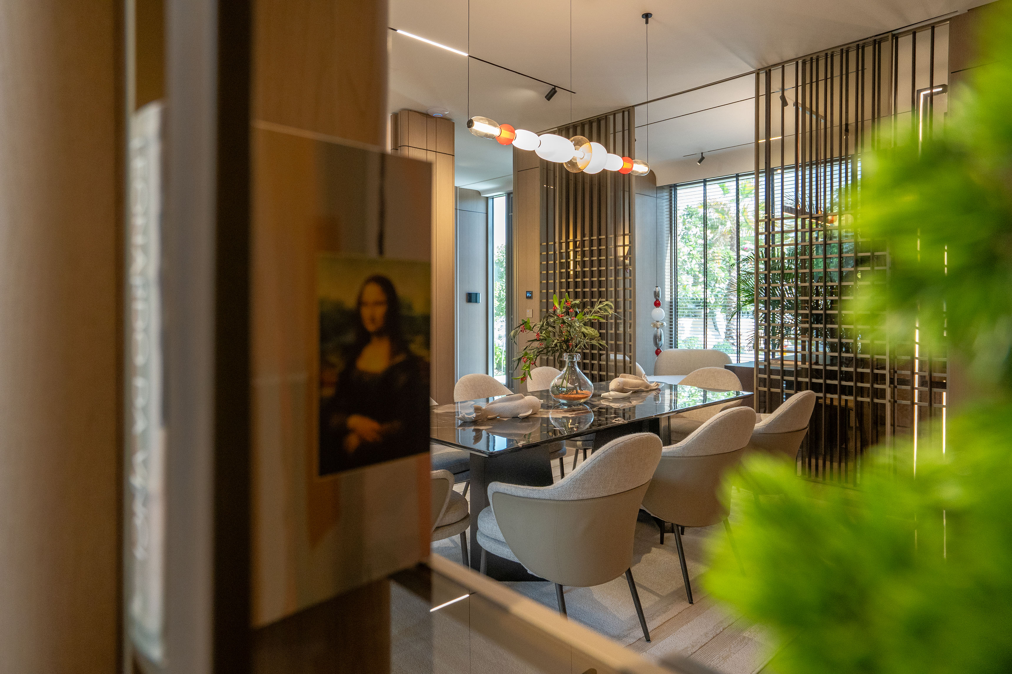 Modern interior showing dining are, office space and chandelier.
