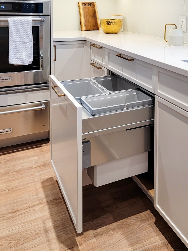 Image of KHD Homes kitchen design with pull-out trash cans and custom cabinetry layout design renovation.