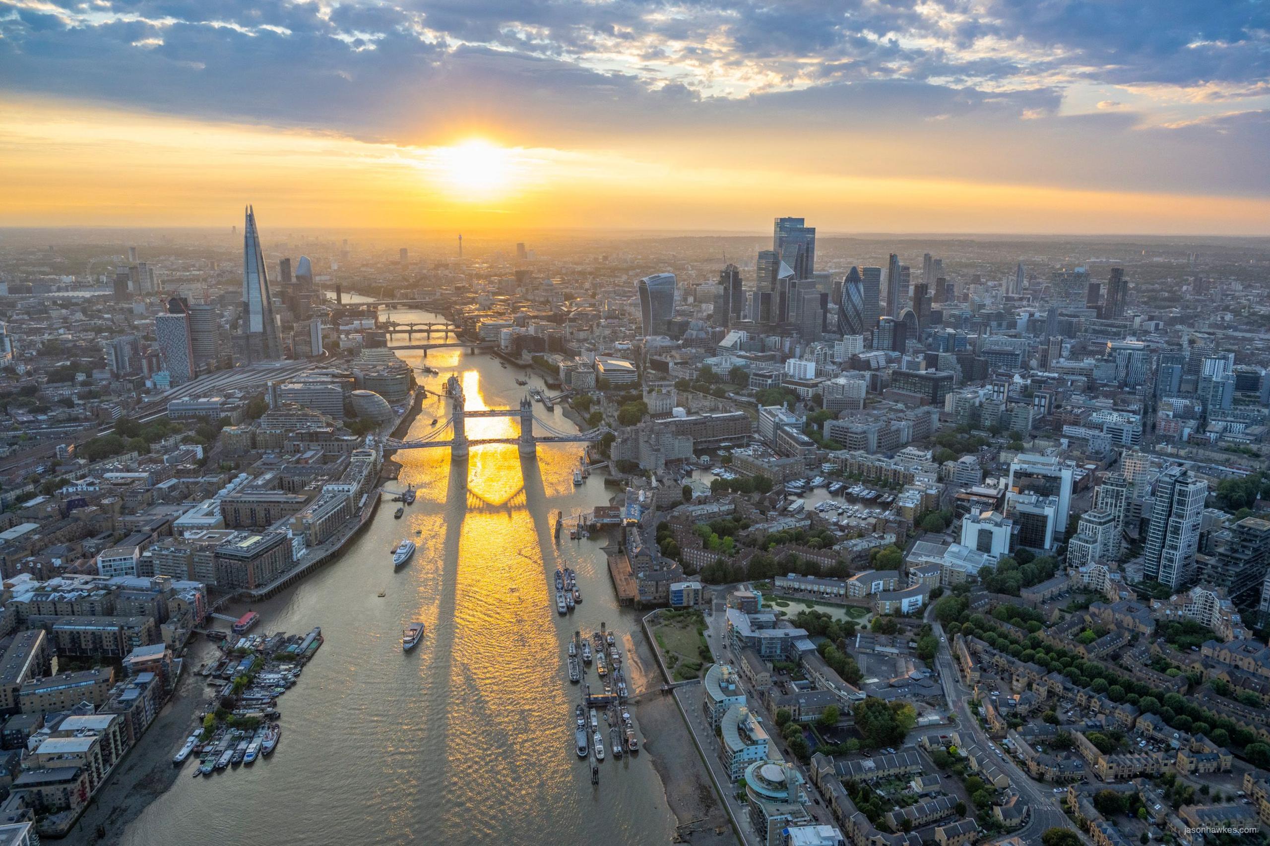Aerial view of London at sunset showing the Thames, Tower Bridge and city skyline