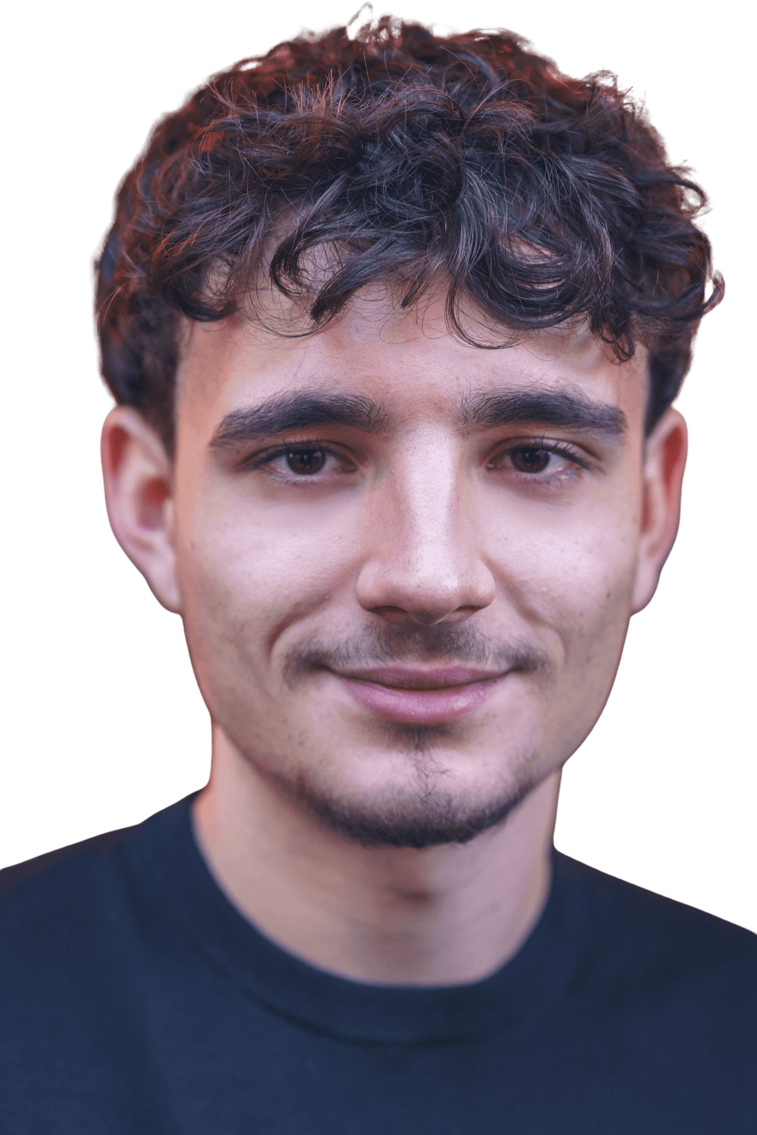 Ein junger Mann mit lockigem Haar und einem leichten Lächeln, der ein schwarzes Hemd vor einem neutralen Hintergrund trägt.
