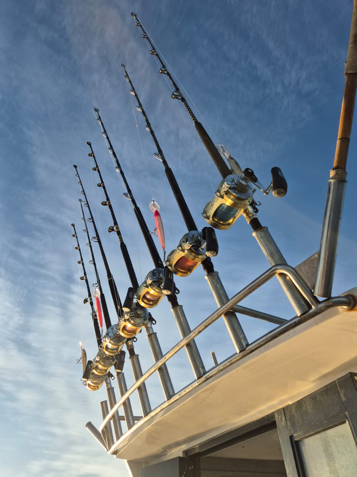 Fishing vessel with rods, reels, and tackle ready for charter.