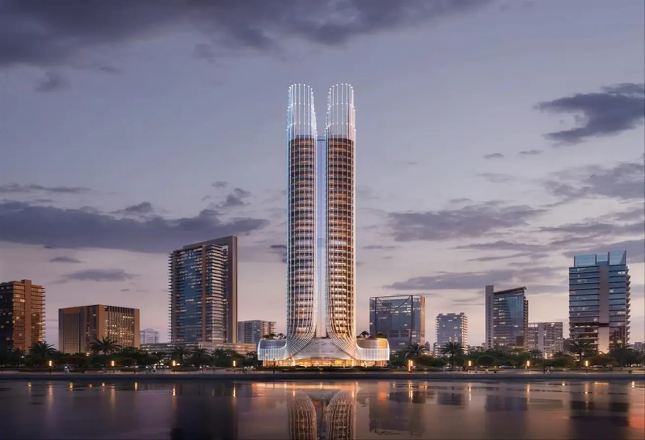 Wide angle view of Binghatti Skyhall’s twin towers rising in the Dubai skyline at sunset.