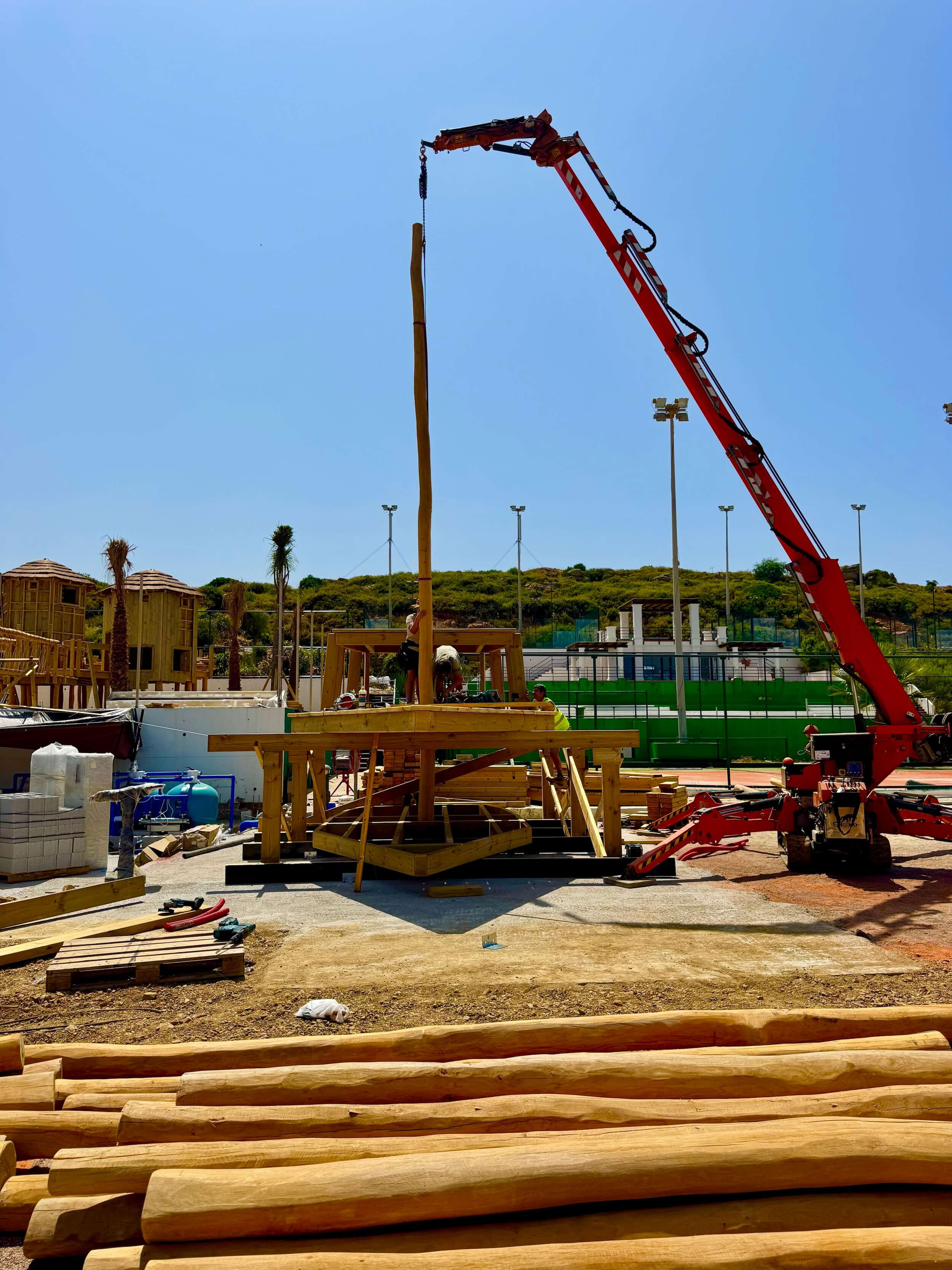 Construction workers building a wooden deck frame in a garden.