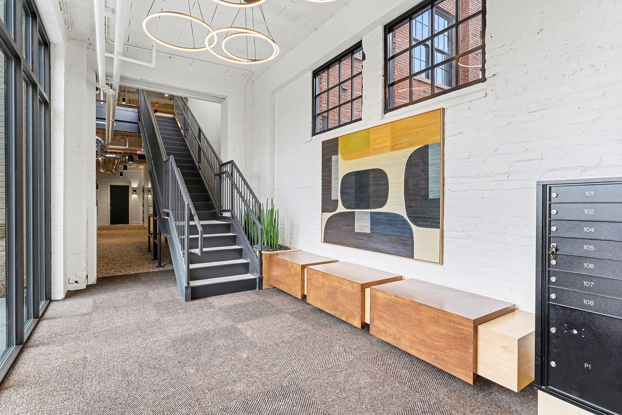 A large white building with a modern architectural design, featuring multiple windows and a clear blue sky in the background.
