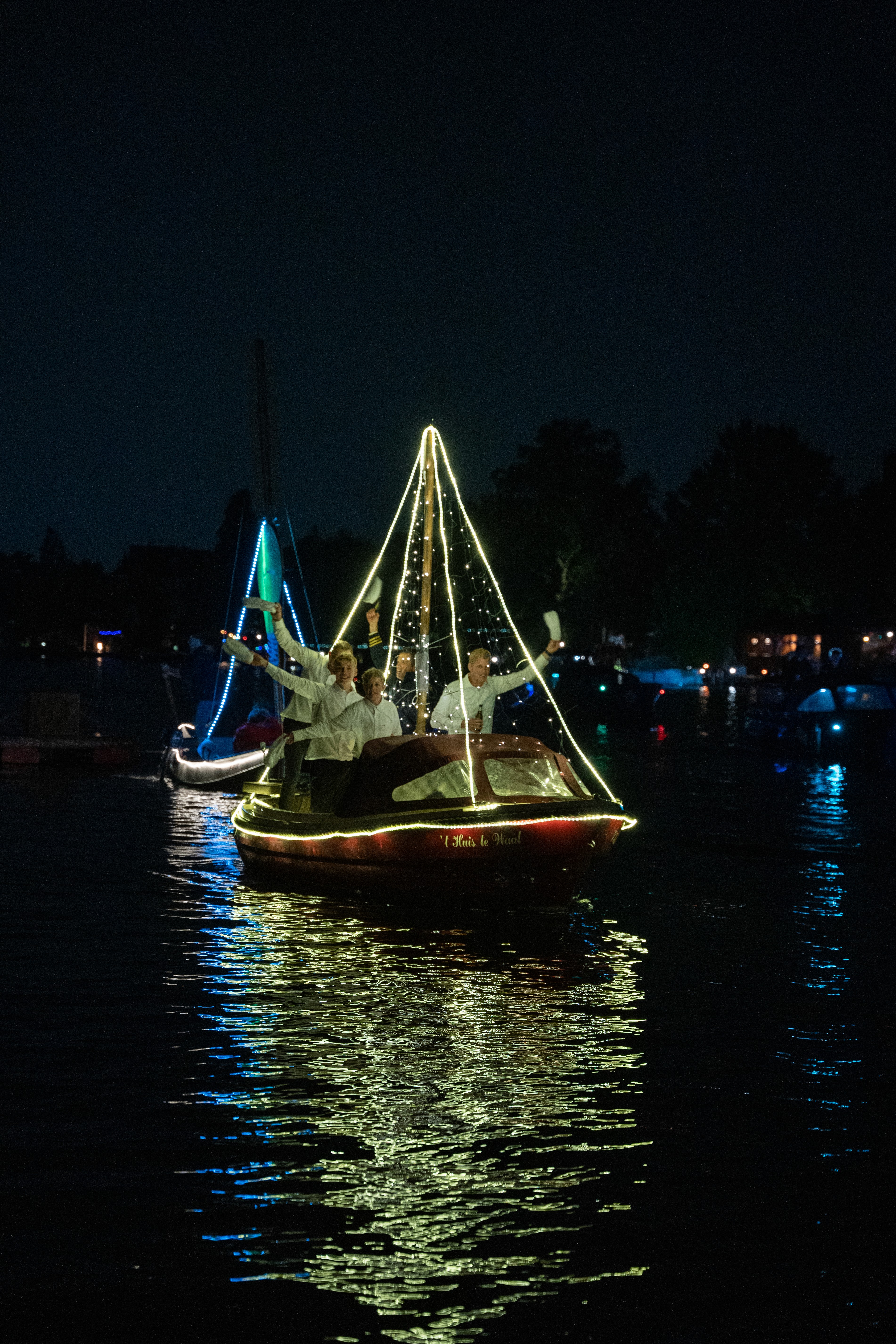 A female volleyball player in a white jersey (number 16) in a defensive stance near the net during a match.