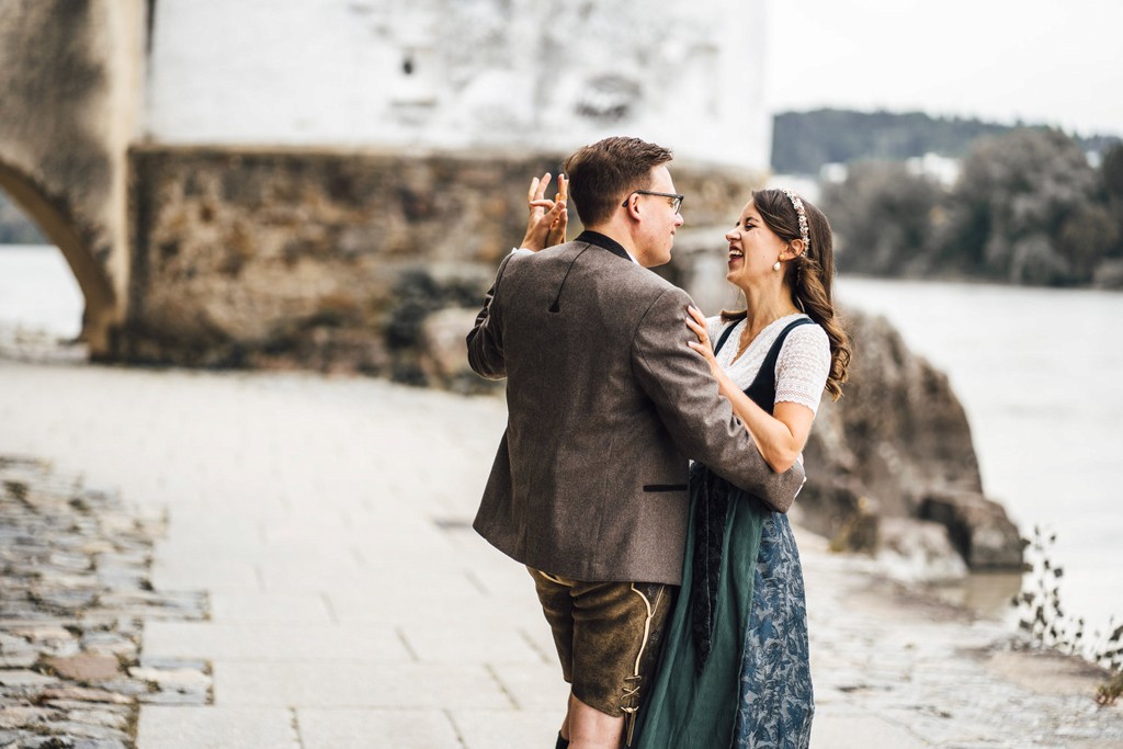 Brautpaar in Tracht tanzt am Donauufer während Hochzeit in Passau