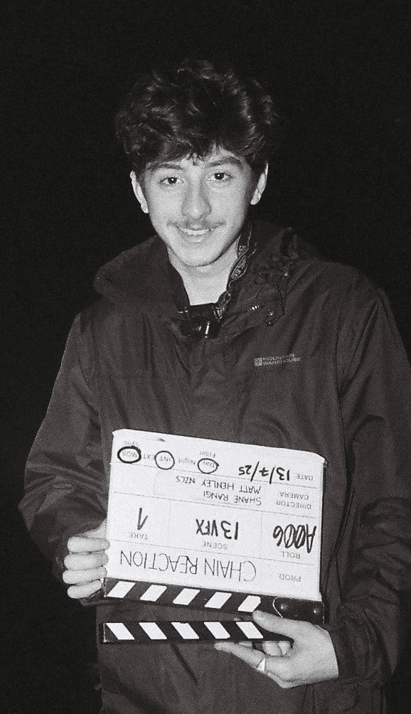 Portrait of a person in a pink sweater against a light background