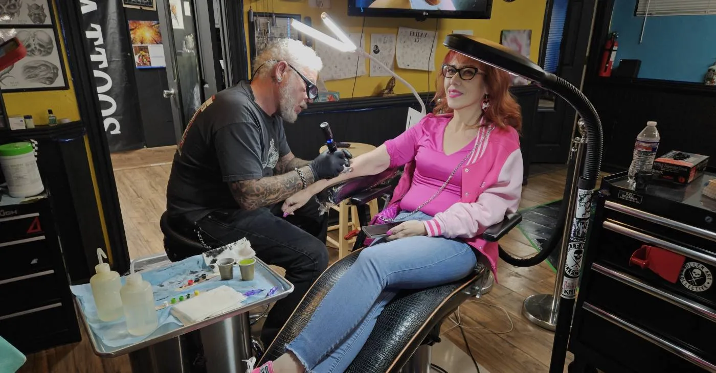 shallow focus photo of person tattooing person's right arm