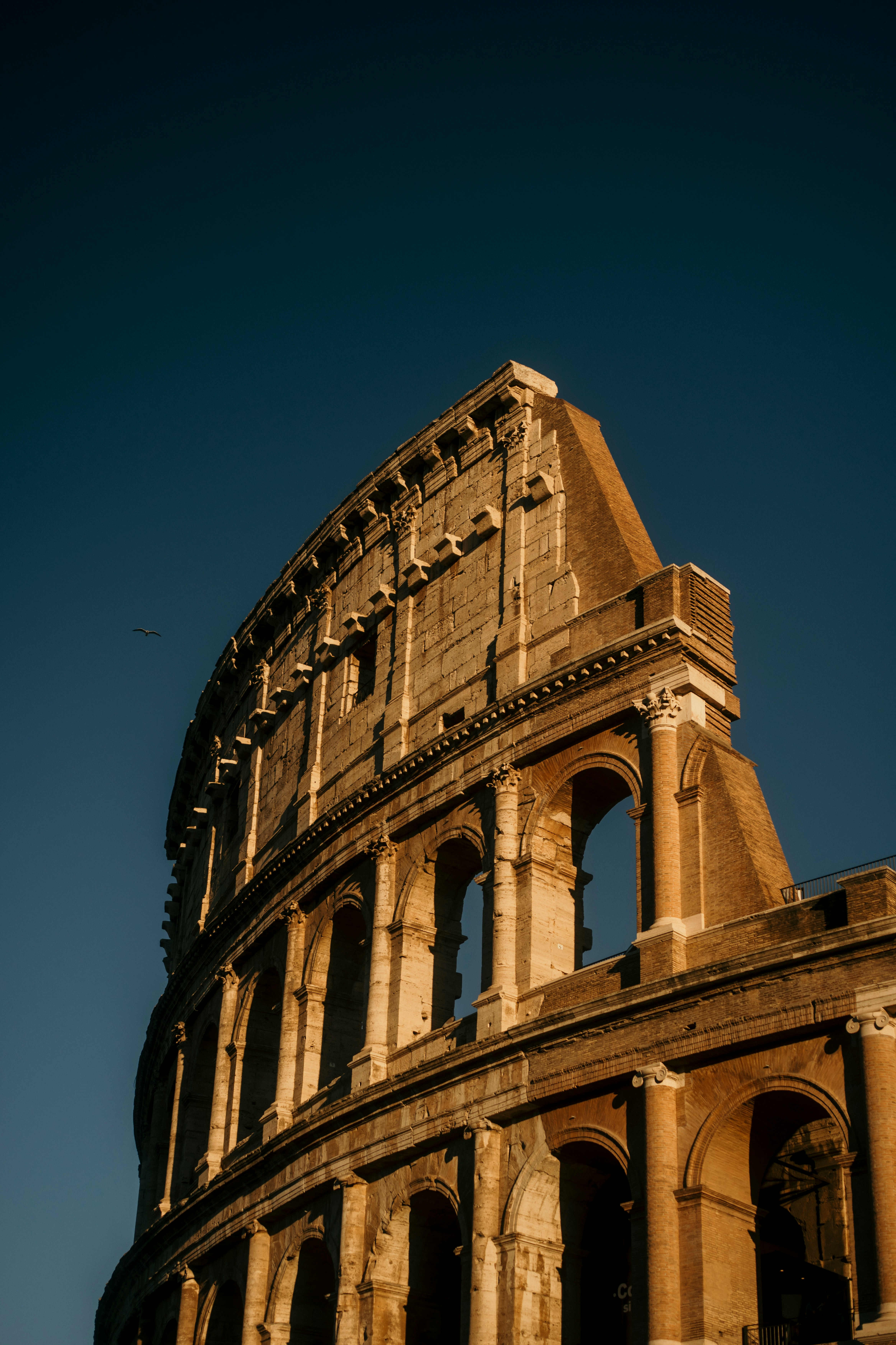 The ancient colosseum under a clear blue sky.