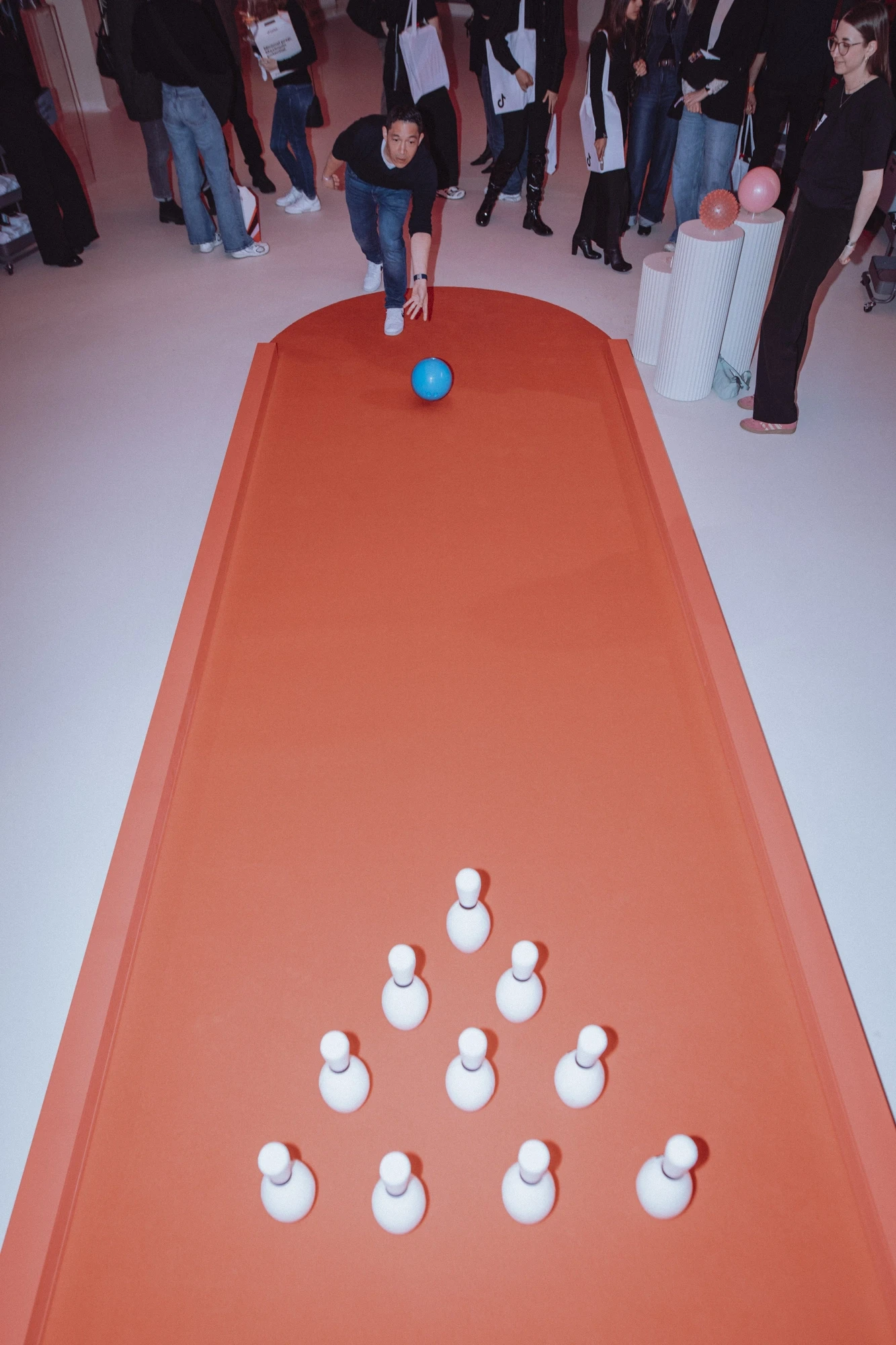 Guest bowling on the orange lane with white pins at the TikTok Showtime event.