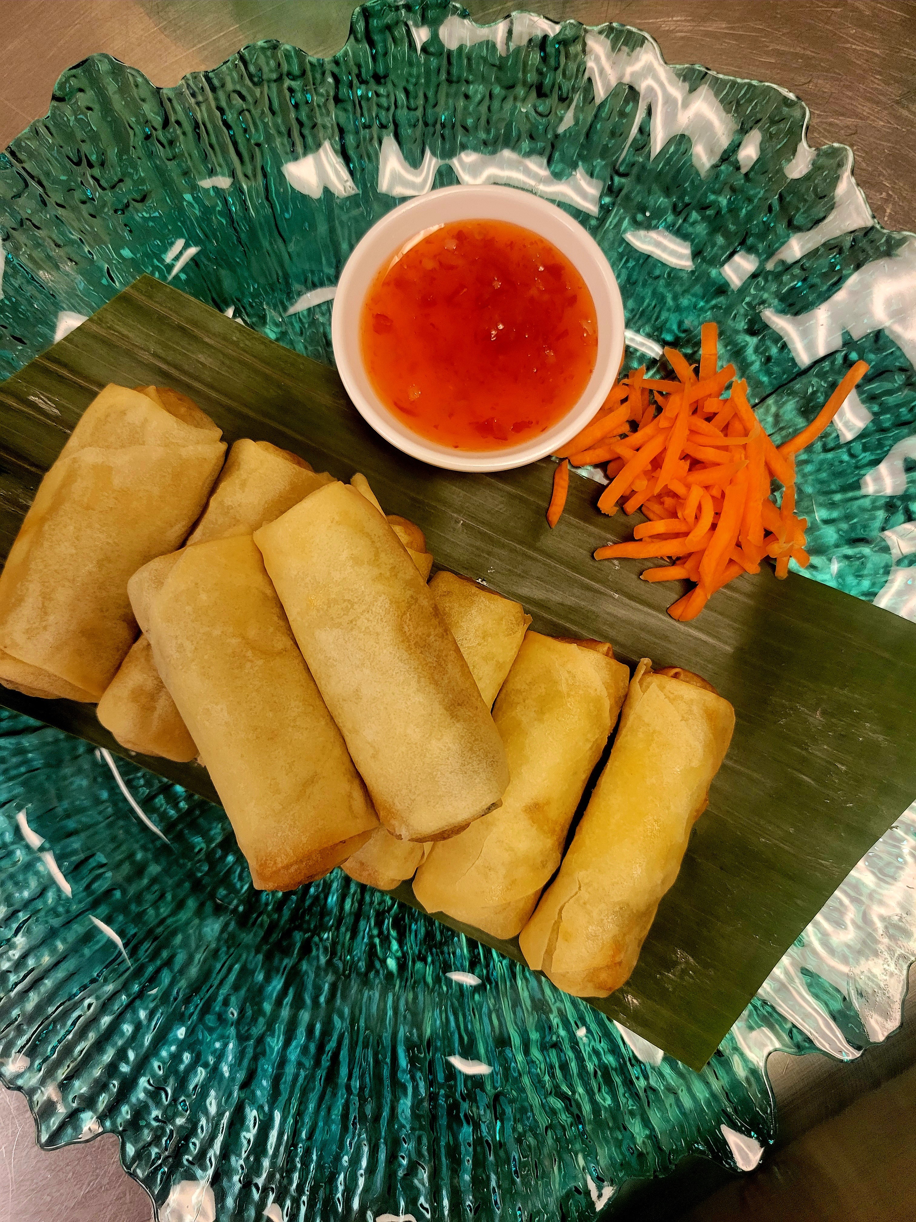 Close-up of the crispy texture and fresh vegetable filling of our signature spring rolls.