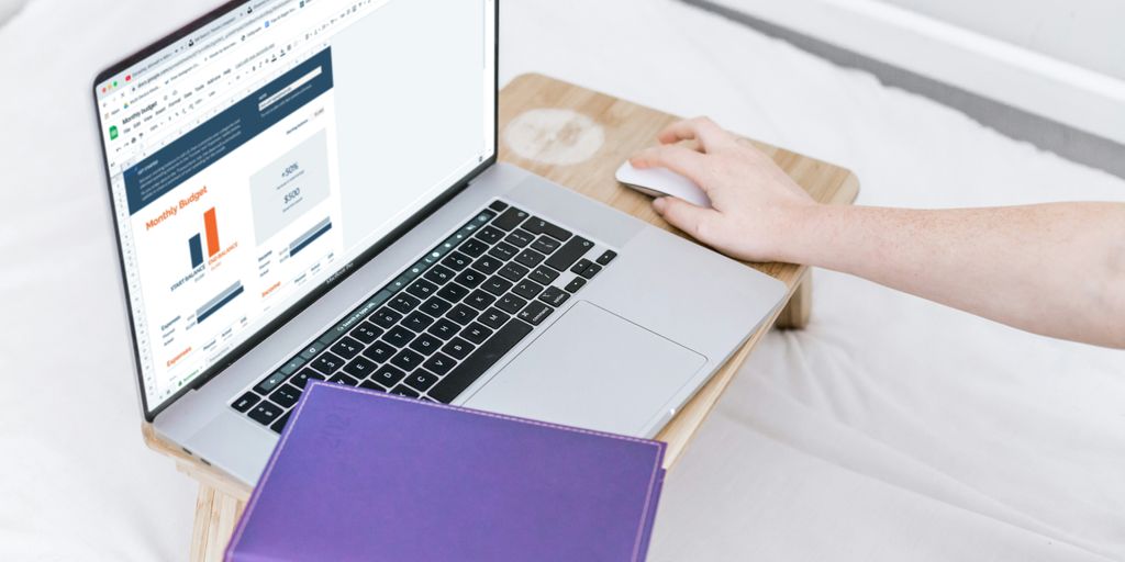 a person using a laptop computer on a bed